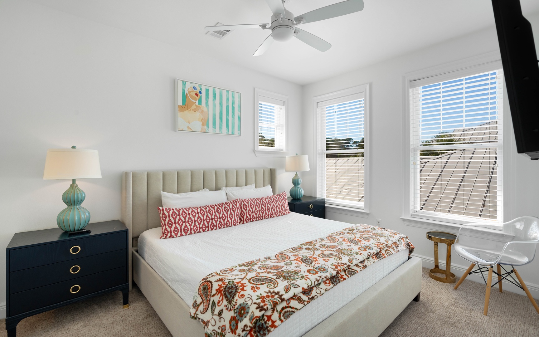 Sink into your plush bed surrounded by cheerful artwork, turquoise accents, and refreshing ceiling fan breezes in this bright, stylish retreat.