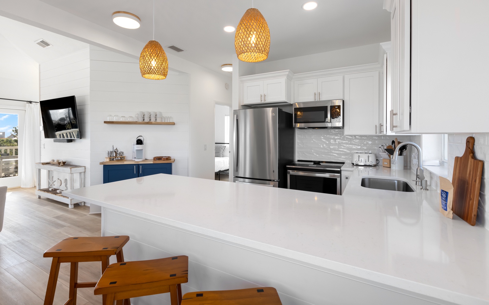 You'll love cooking in this bright, modern kitchen with its spacious island, stainless steel appliances, and warm pendant lighting creating the perfect space for meals.