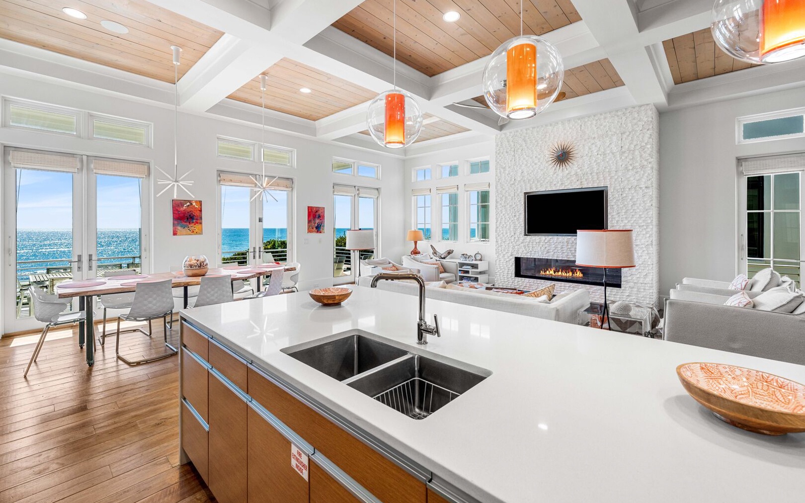 Cook while gazing at stunning ocean views through floor-to-ceiling windows in this bright open-plan kitchen and living space.