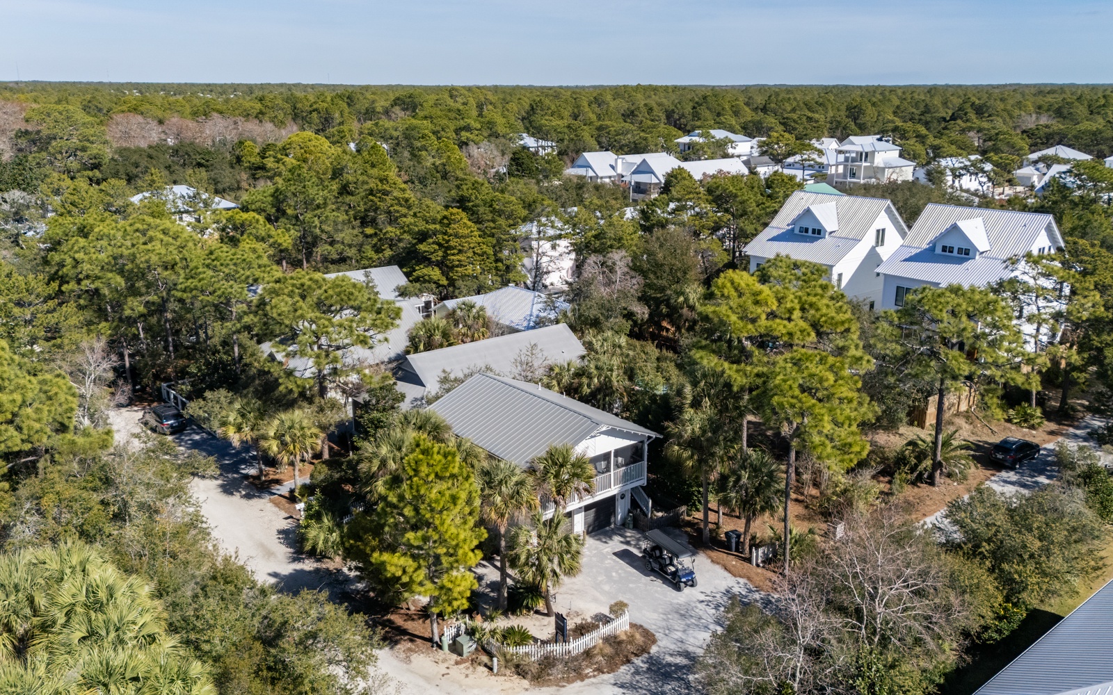 Peaceful coastal neighborhood with the property nestled among native trees and vacation homes.