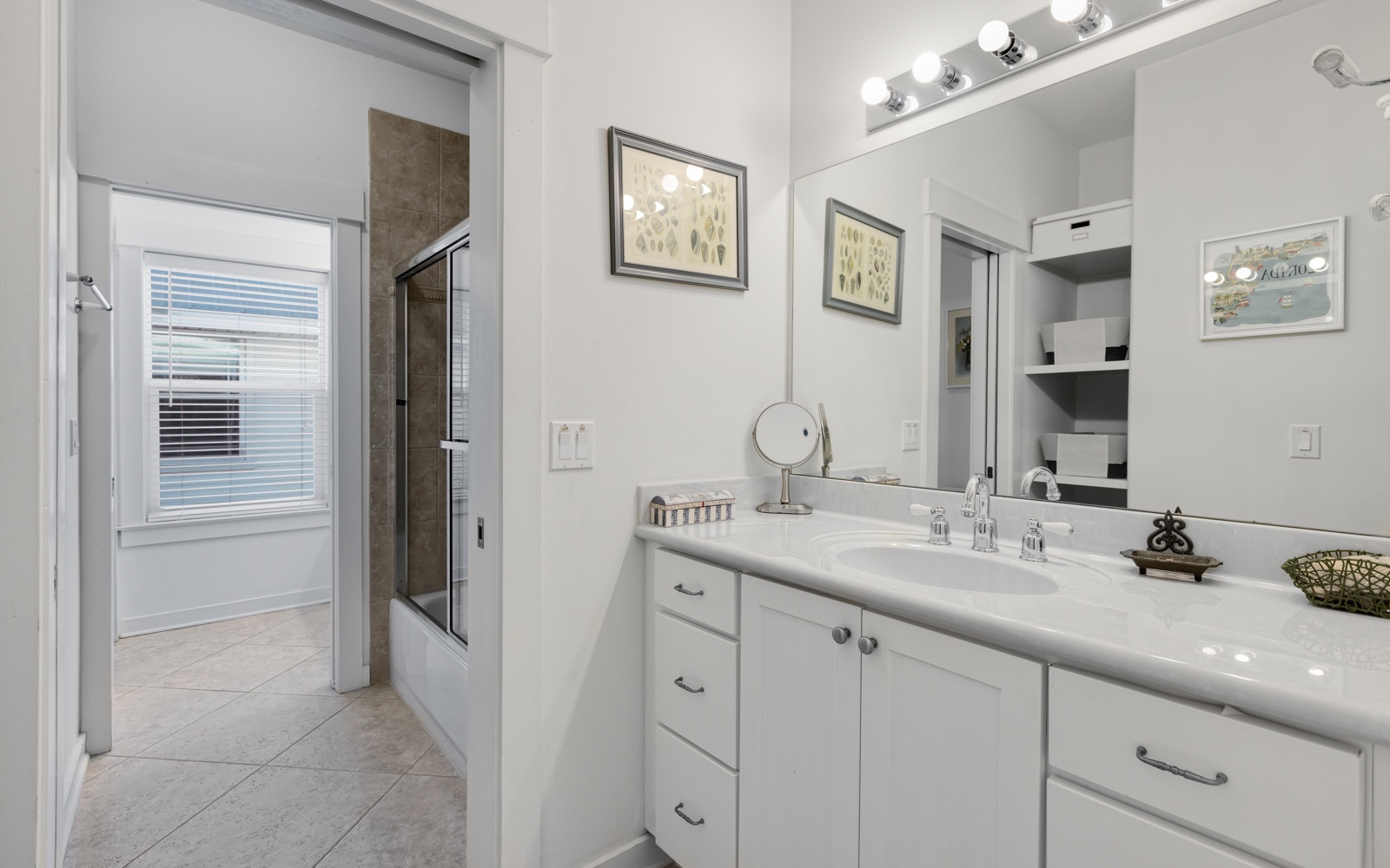 Step into your pristine bathroom with gleaming countertops, elegant vanity lighting, and a spacious shower waiting for your morning routine.