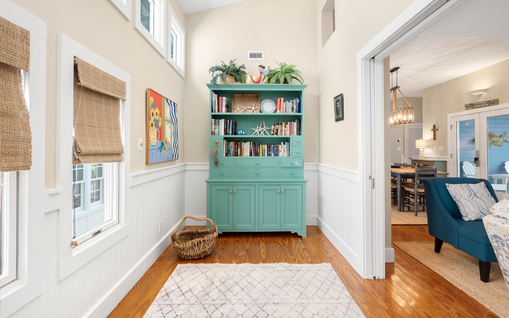 Your private reading nook awaits with turquoise built-ins, natural light, and cozy coastal charm perfect for morning coffee.