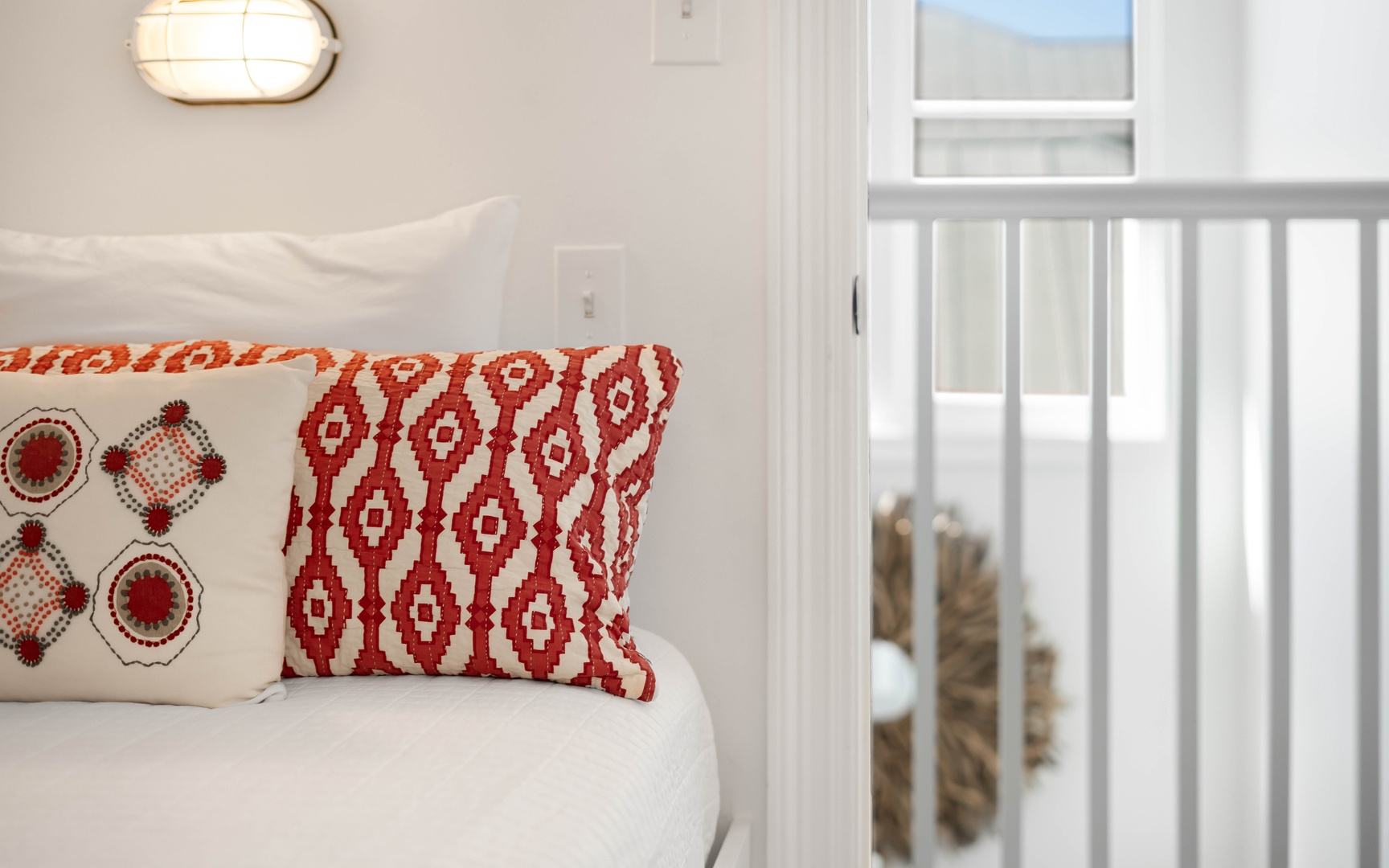 Sink into plush comfort with vibrant red pillows and soft lighting creating your perfect reading nook.