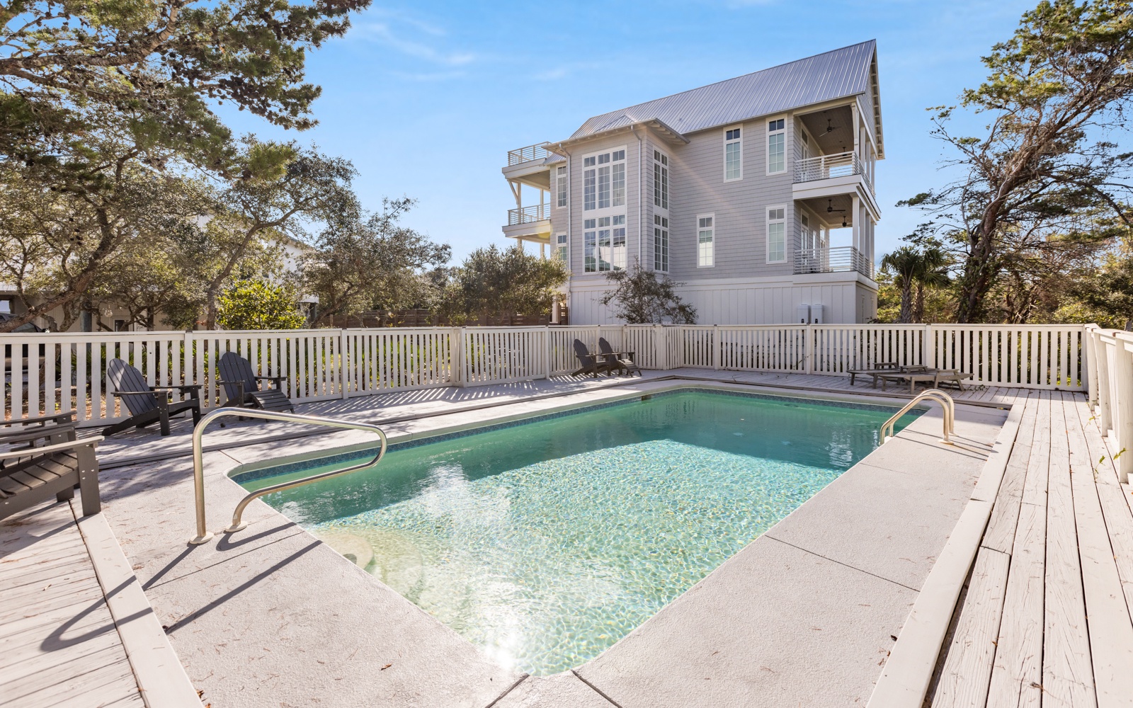 A sparkling private pool awaits your relaxation, surrounded by comfortable lounge chairs and mature oak trees for natural shade and serenity.