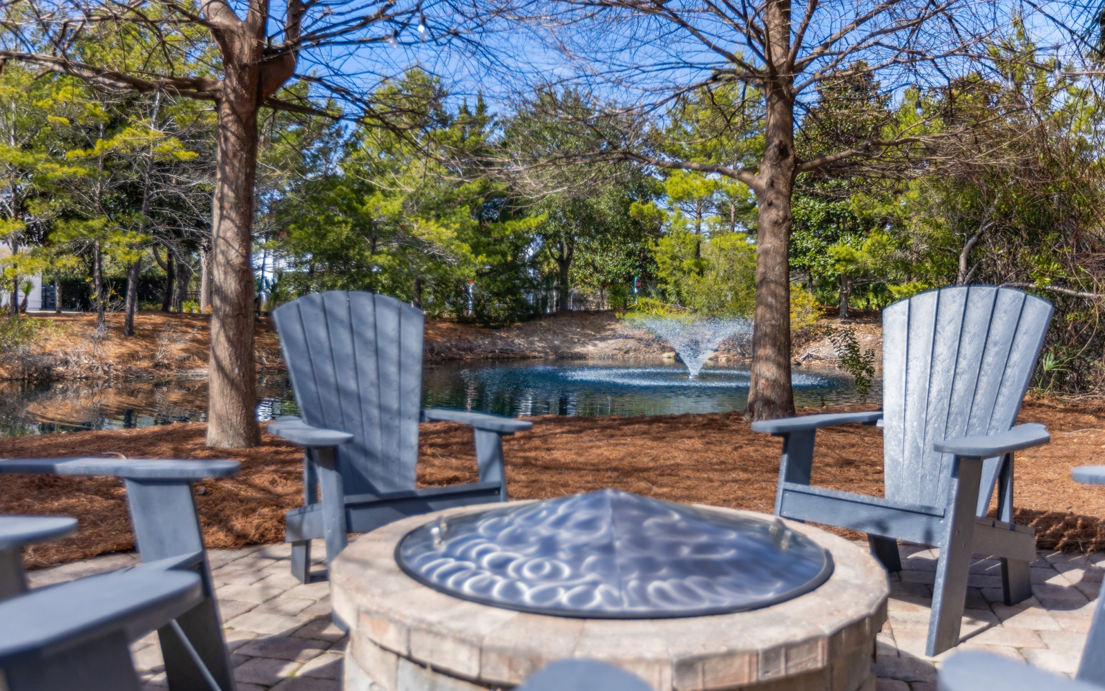 Relax in comfortable Adirondack chairs around your private fire pit, overlooking a peaceful pond with fountain views through mature trees.