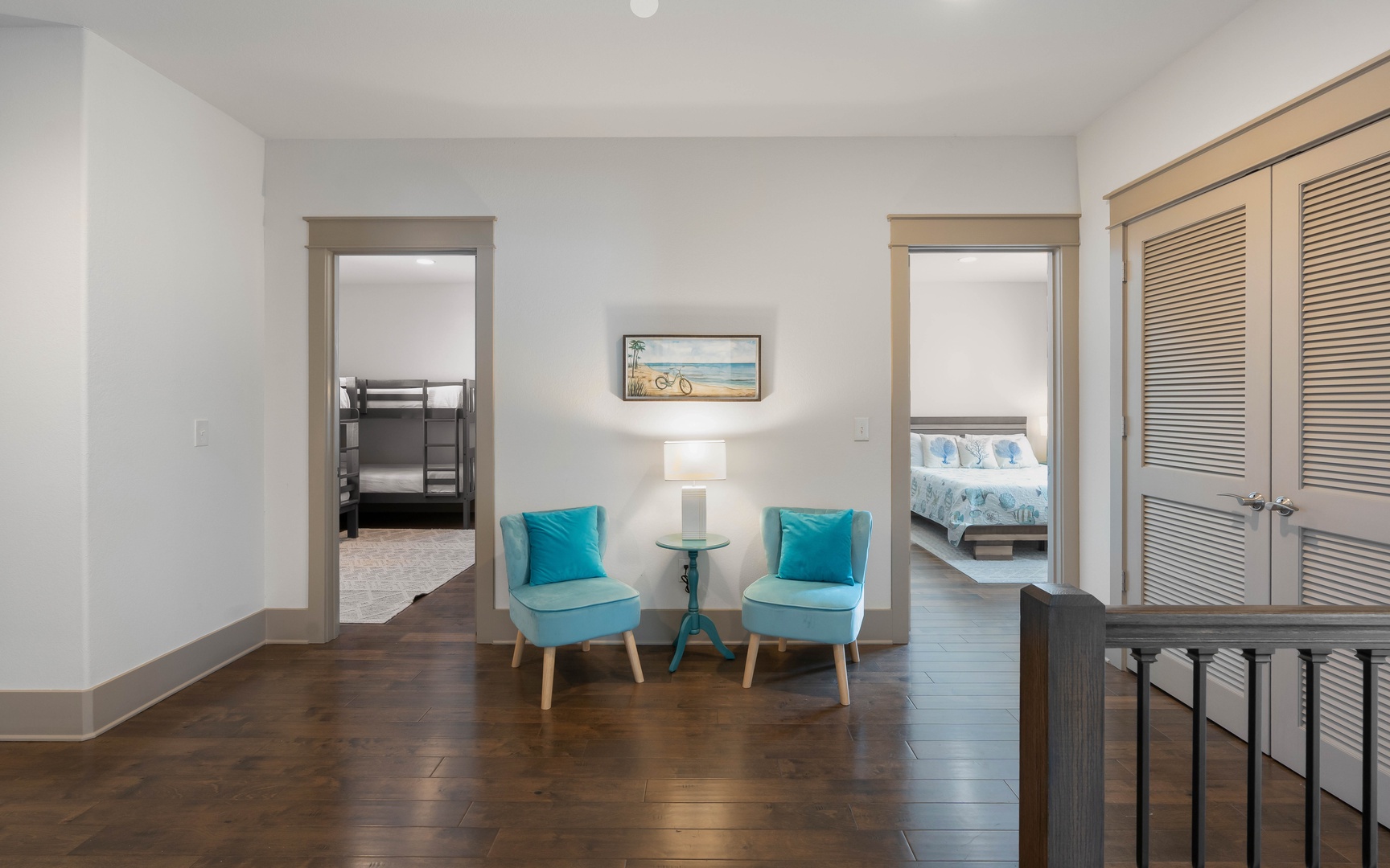 Your comfortable sitting area connects the bedrooms, with stylish turquoise chairs perfect for morning coffee or evening relaxation.