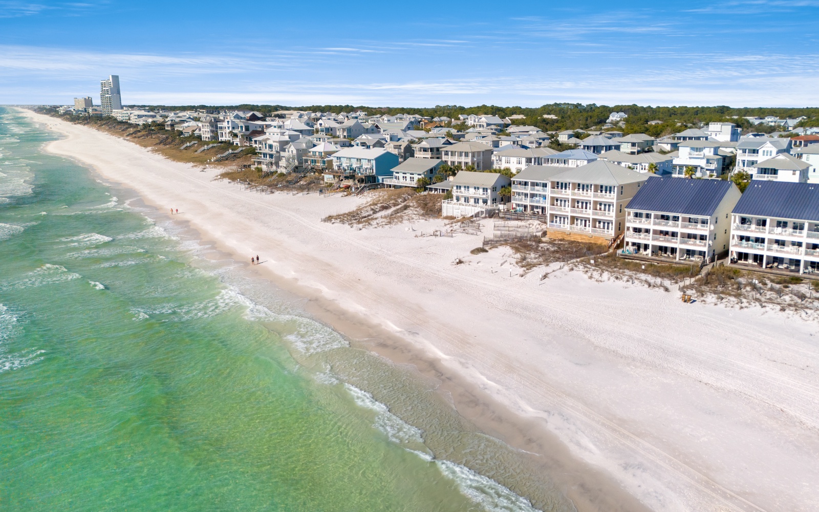 Pristine beachfront community featuring colorful vacation homes along white sand shores with emerald Gulf waters.