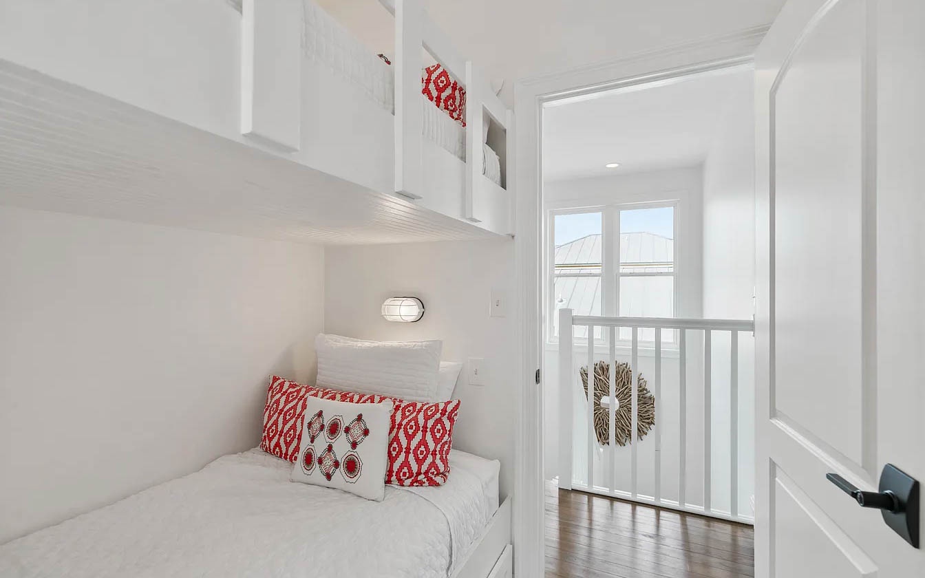 Slip into your own private nook with crisp white linens and charming red accent pillows - perfect for afternoon reading or peaceful rest.