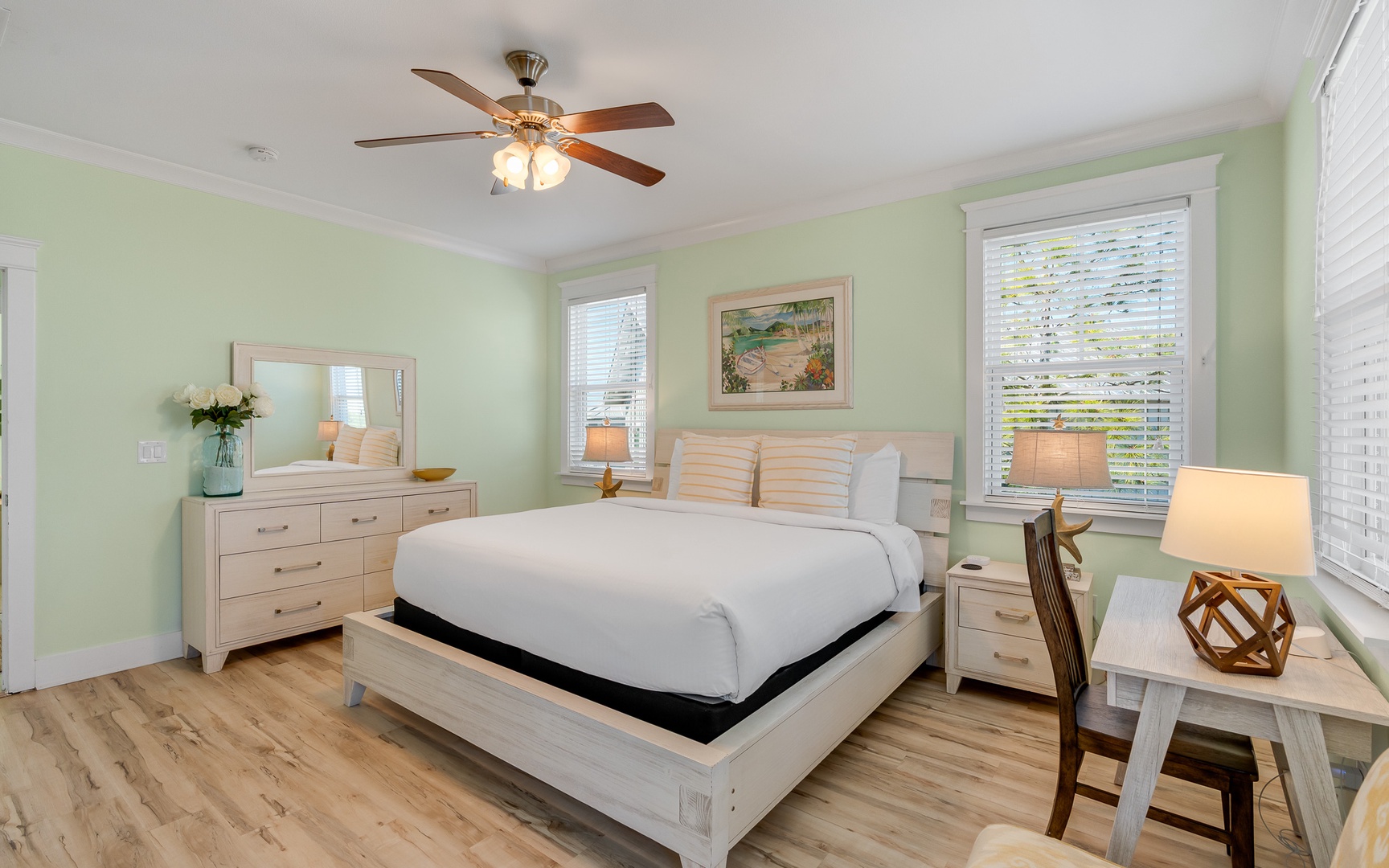 Drift off to sleep in your peaceful mint-green bedroom with coastal artwork and gentle ceiling fan keeping you comfortable all night.