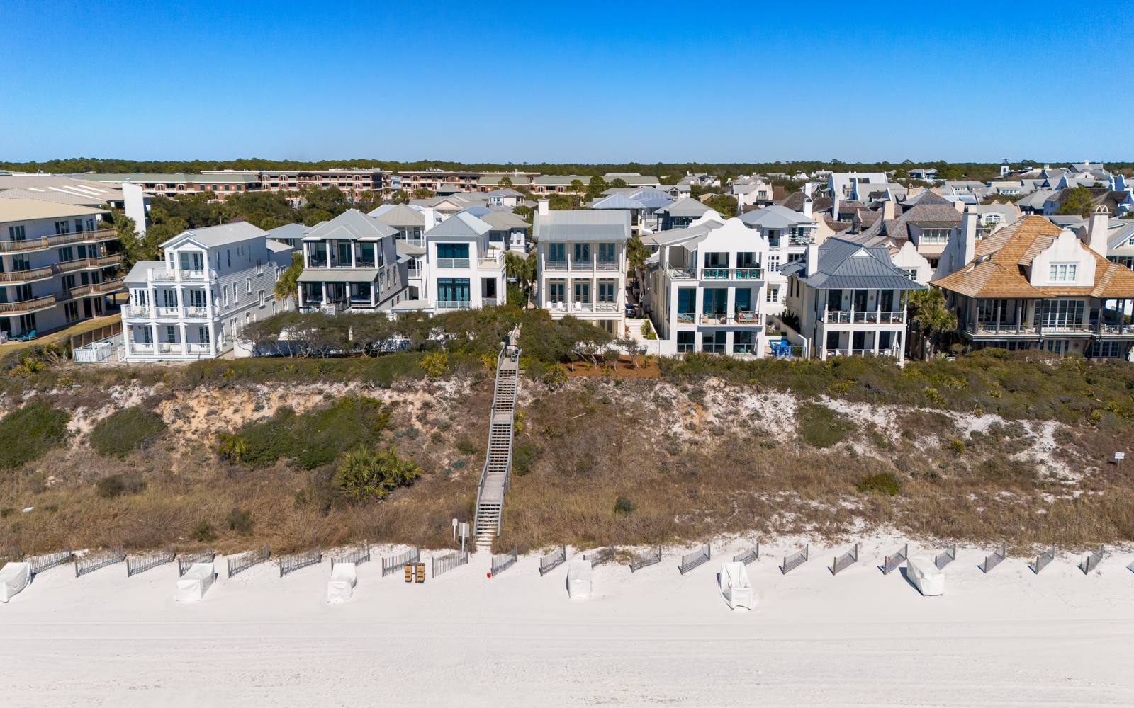 Elegant beachfront homes line pristine white sand with easy boardwalk access to the shore.