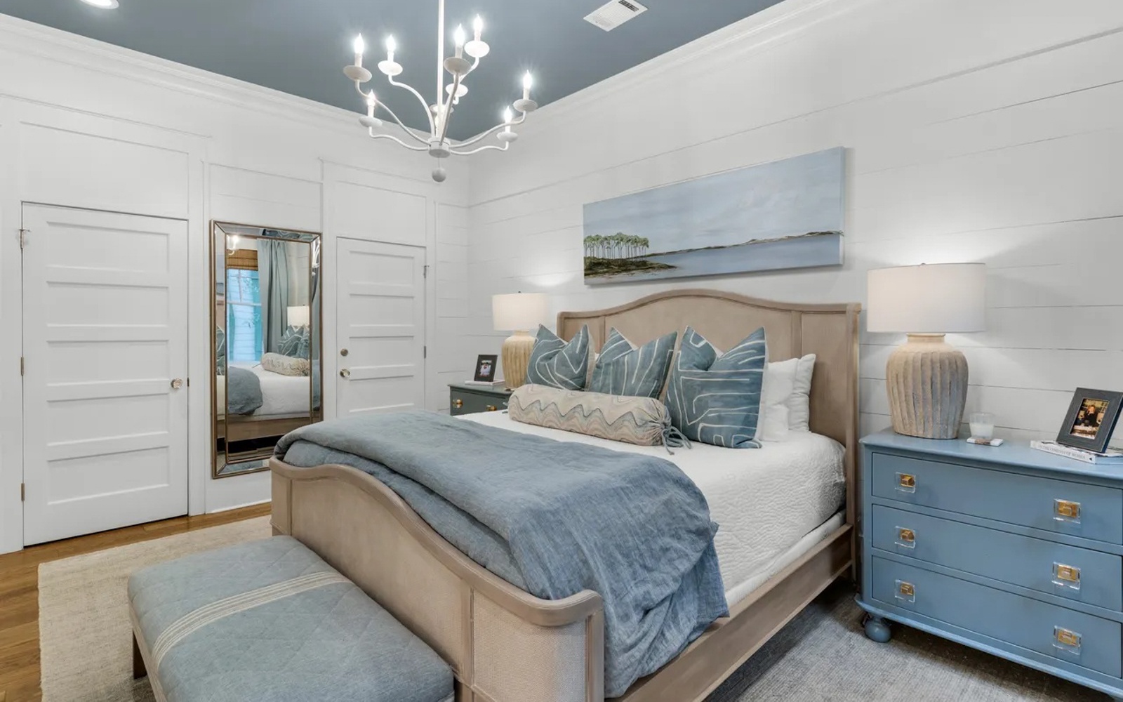 Sink into this serene master suite where soft blues and whites create your perfect coastal retreat.
