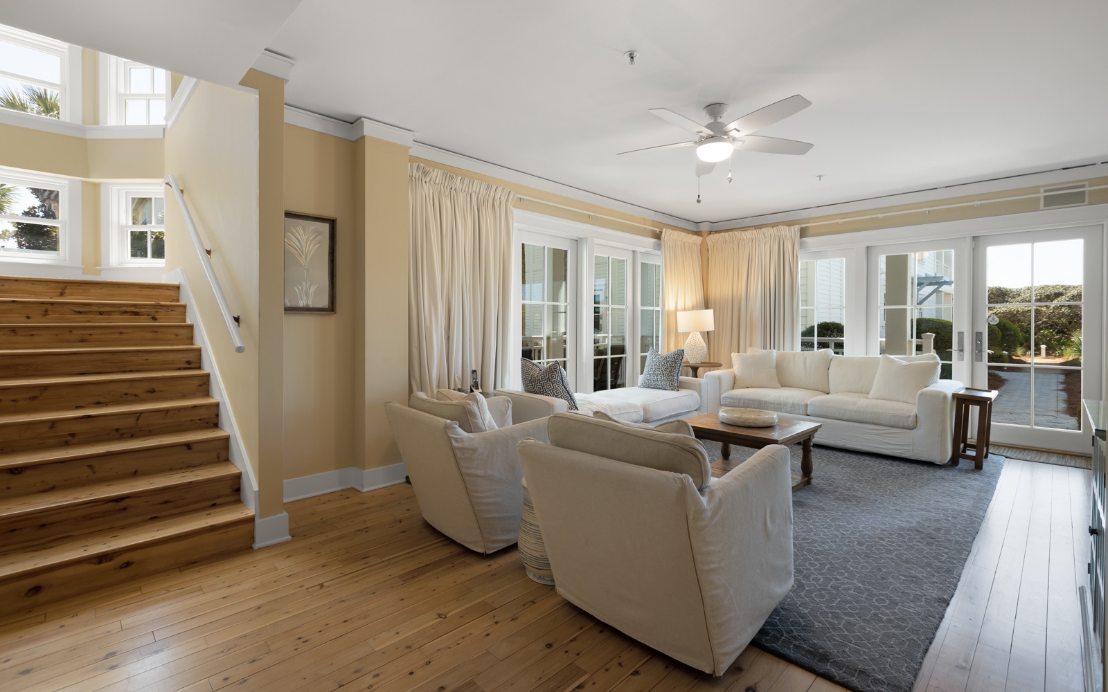 Sink into plush sofas in your bright, airy living space with soaring ceilings and French doors opening to outdoor serenity.