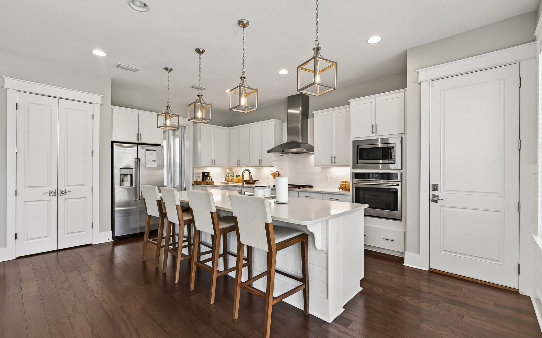 Your gourmet kitchen awaits with sleek white cabinetry, modern appliances, and a spacious island perfect for morning coffee or evening meals together.