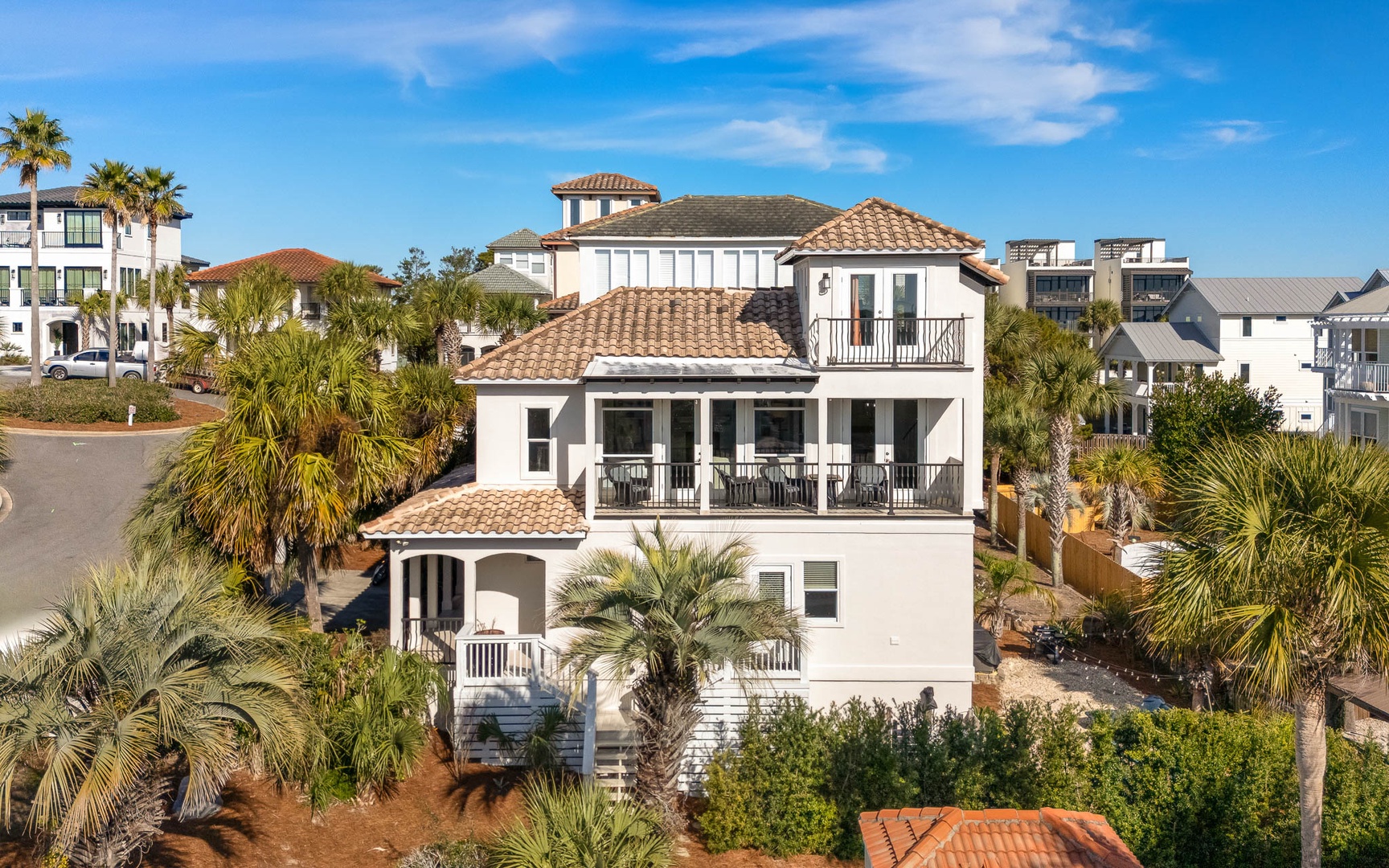 Stunning Mediterranean-style beachside villa surrounded by lush palms in an upscale coastal neighborhood.