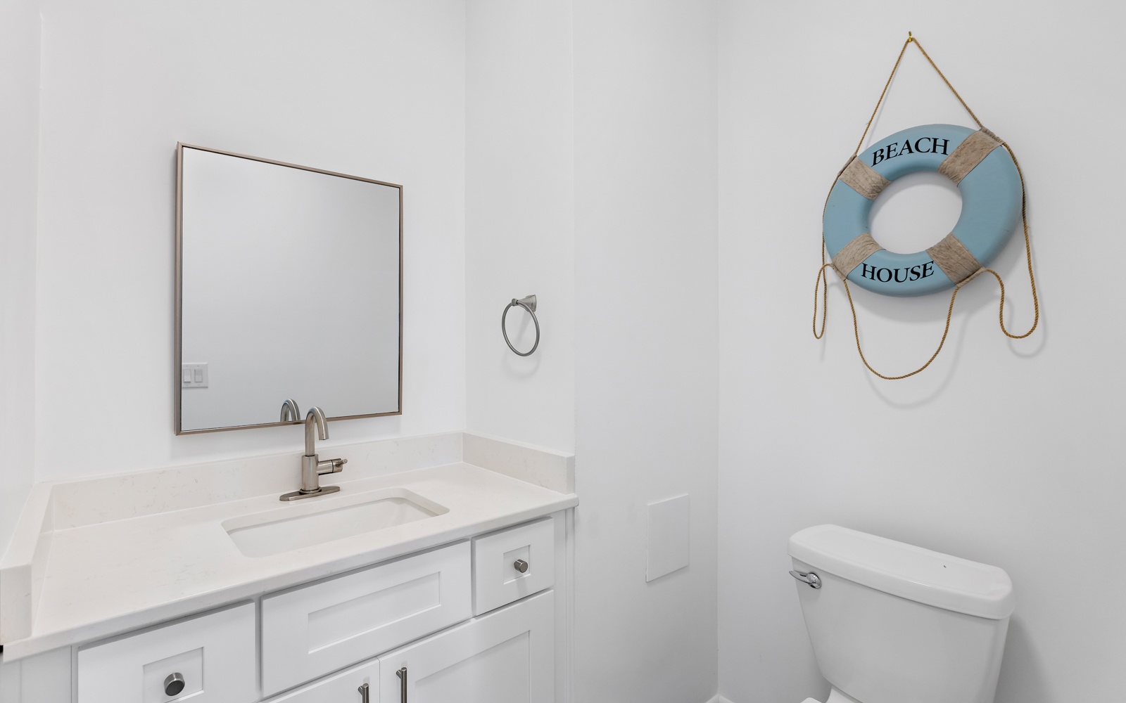 Your coastal-themed bathroom features crisp white finishes and charming beach house decor for a refreshing seaside escape.
