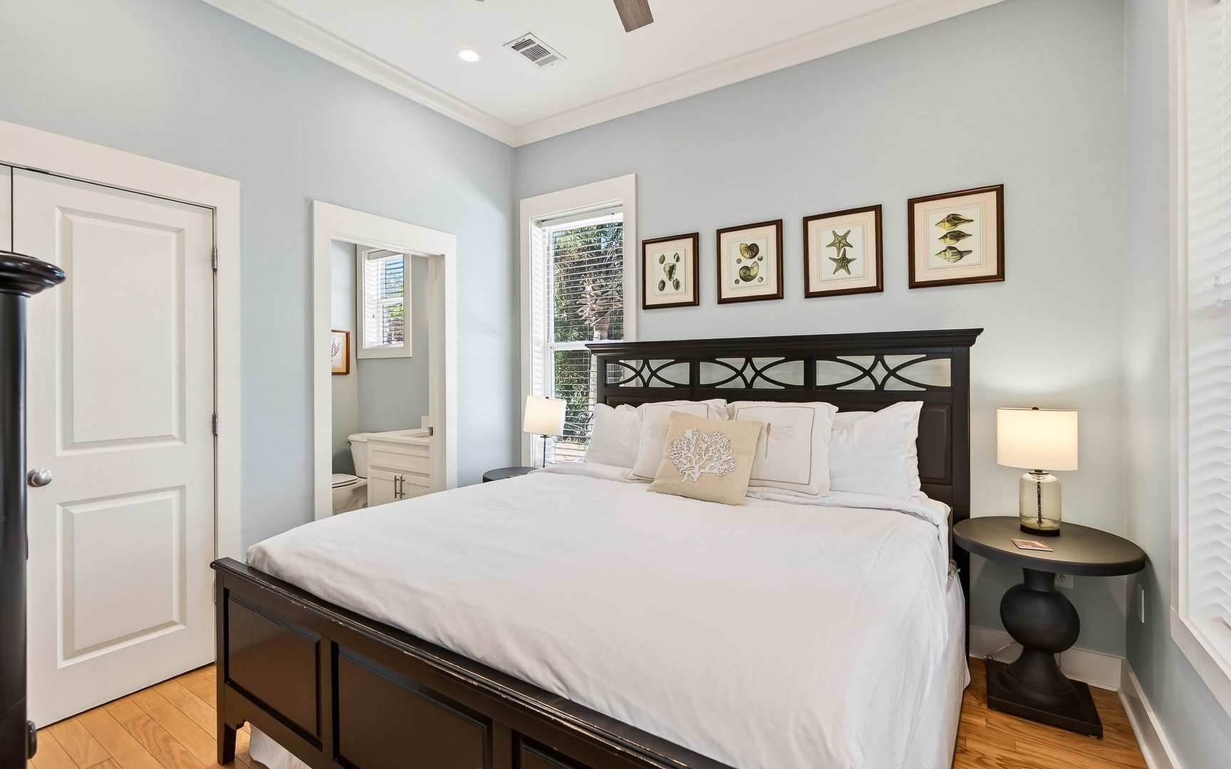 Drift into peaceful sleep in your serene coastal bedroom with crisp white linens and botanical artwork creating a tranquil sanctuary.