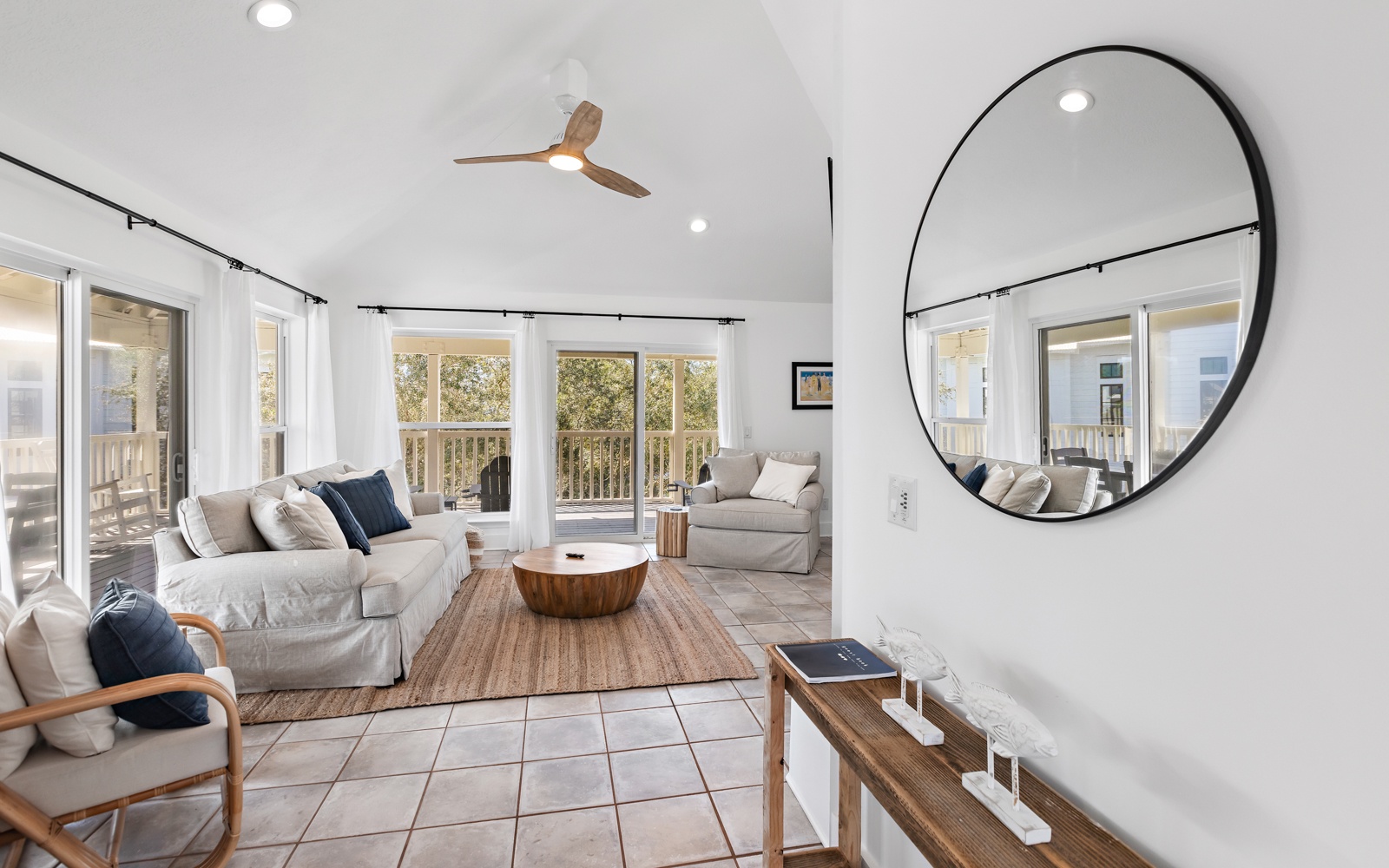 Unwind in your bright, airy living space with cozy seating and natural light streaming through floor-to-ceiling windows.