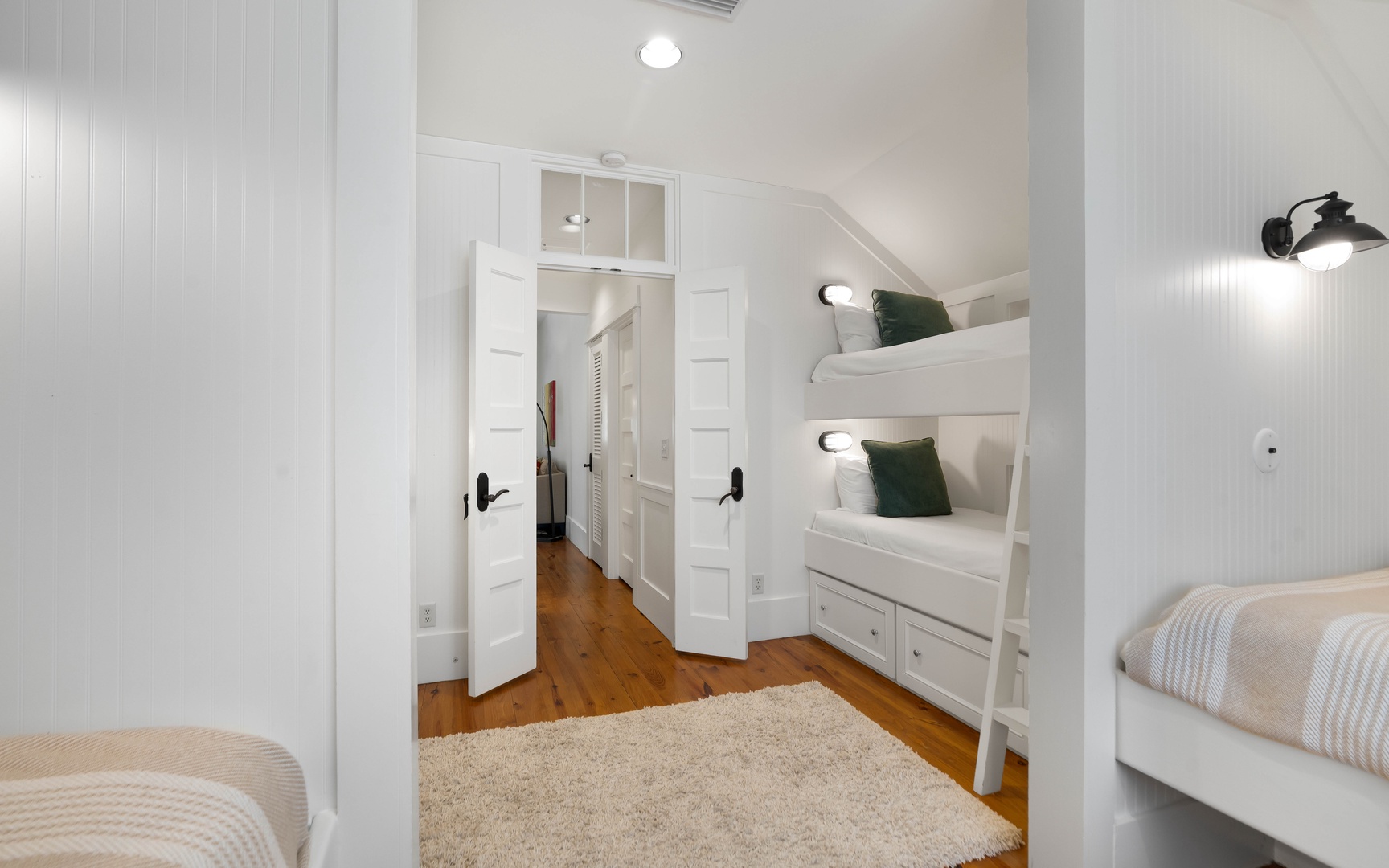 Your family bedroom features custom white bunk beds with cozy built-in storage, perfect for kids or extra guests.