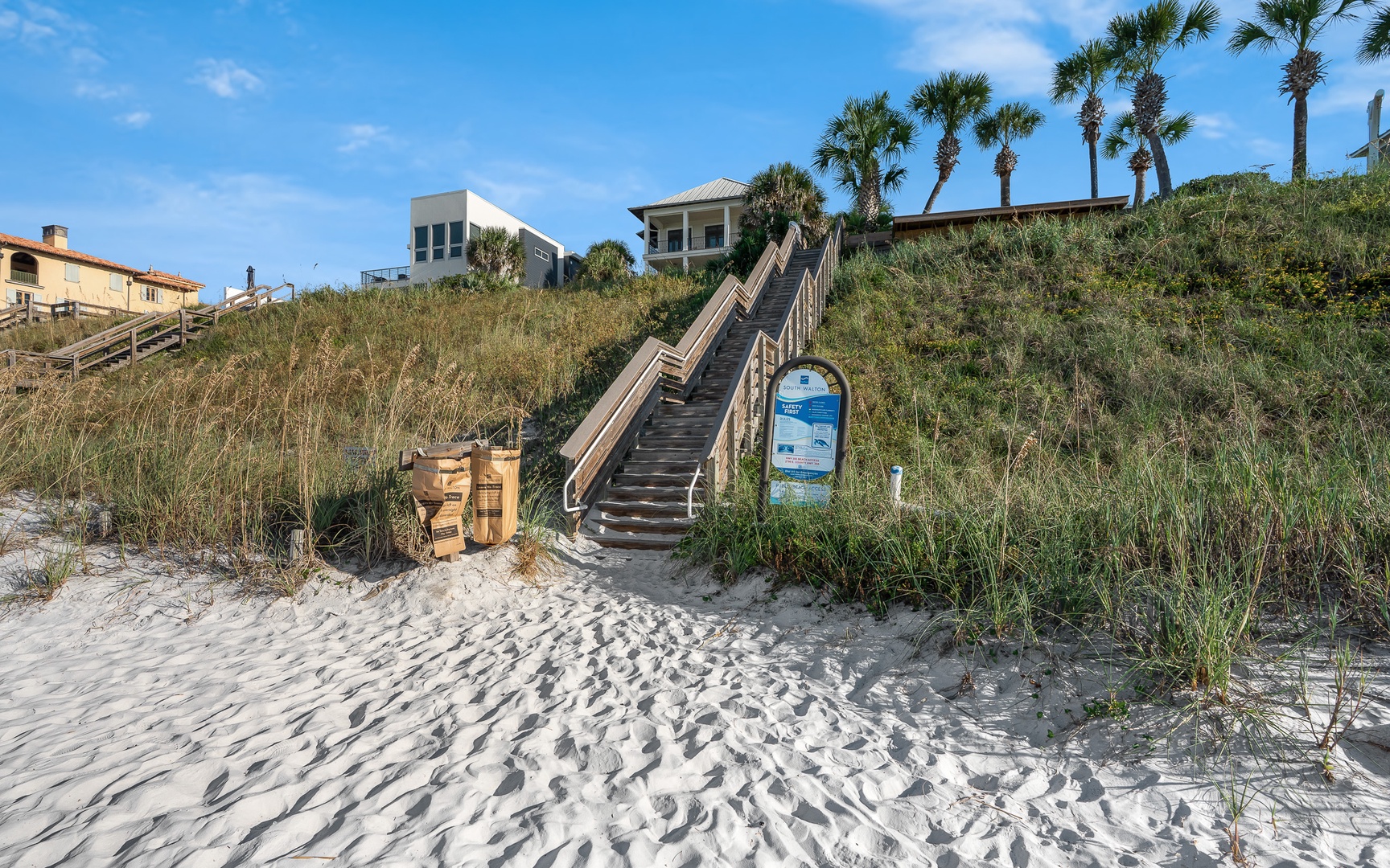 Beachfront vacation homes nestled among palm trees with private beach access just steps away from pristine white sand.