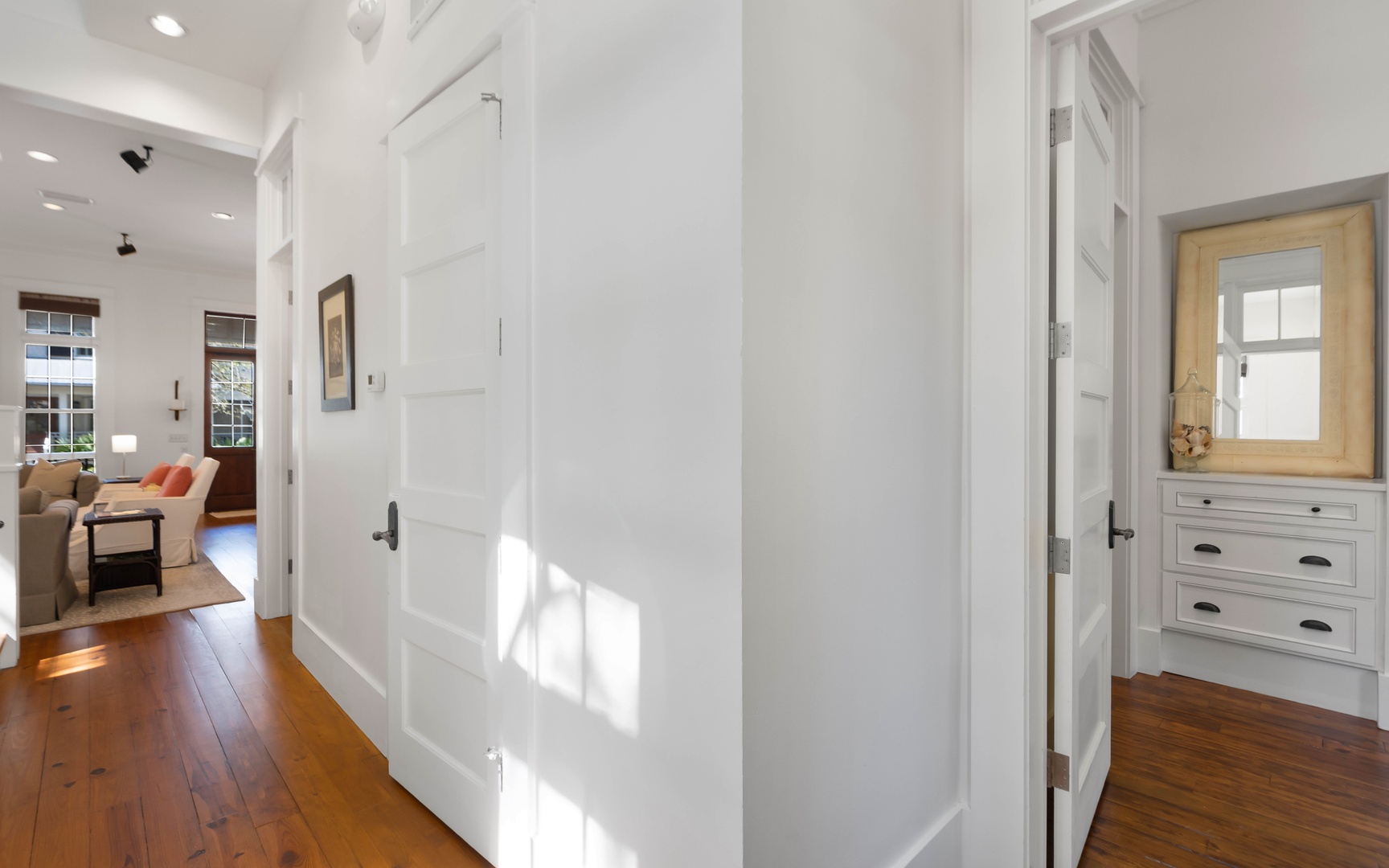 Step into this bright, welcoming hallway where rich hardwood floors guide you through your spacious home away from home.