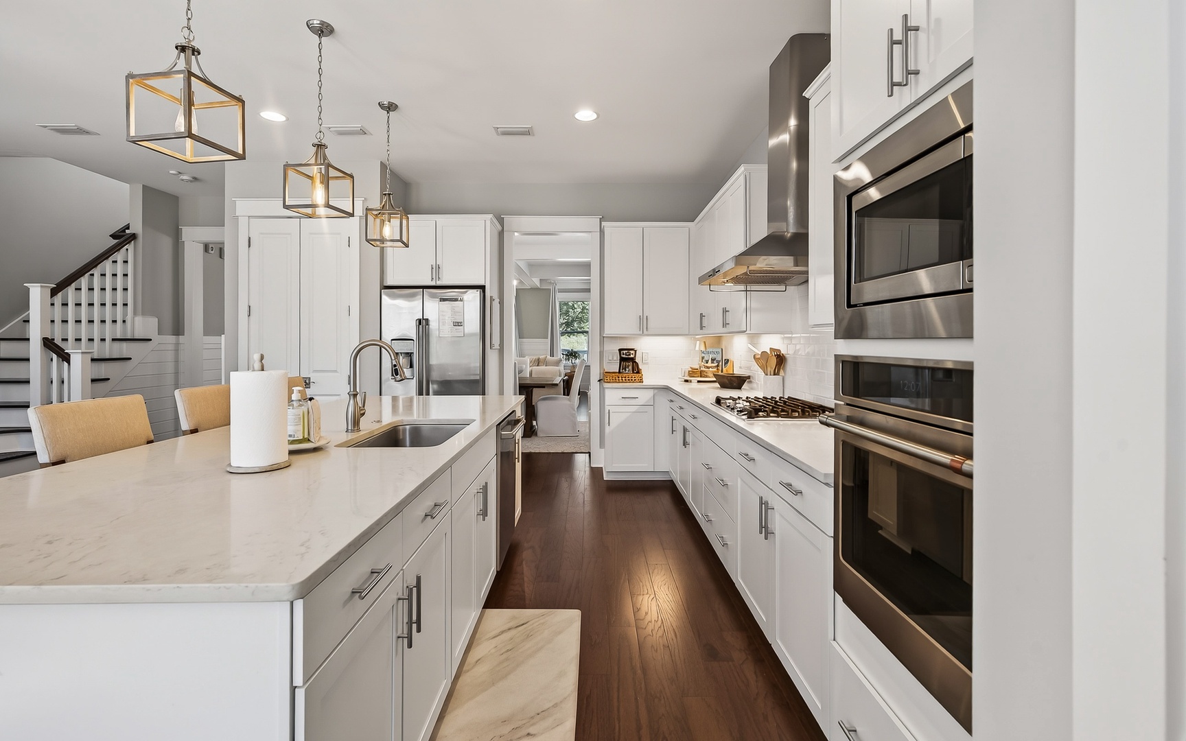 Your gourmet kitchen beckons with pristine white cabinetry, gleaming quartz countertops, and professional-grade stainless steel appliances ready for culinary adventures.