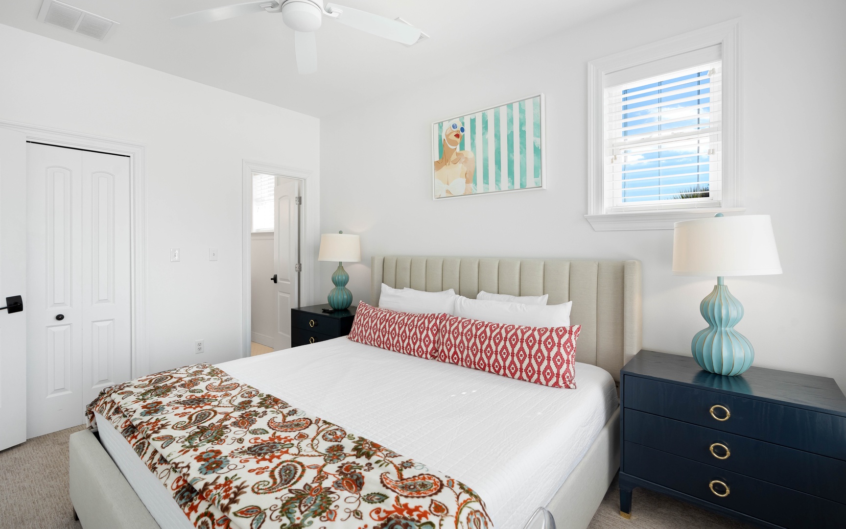 Drift into peaceful sleep in your bright bedroom with plush bedding, stylish coastal decor, and cheerful natural light streaming in.