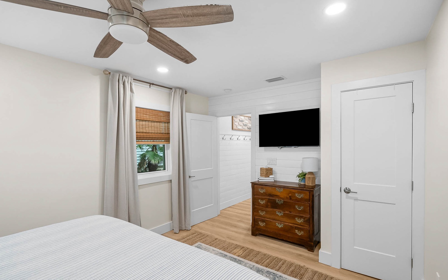 Your peaceful bedroom retreat features a ceiling fan, flat-screen TV, and vintage dresser for comfortable relaxation.