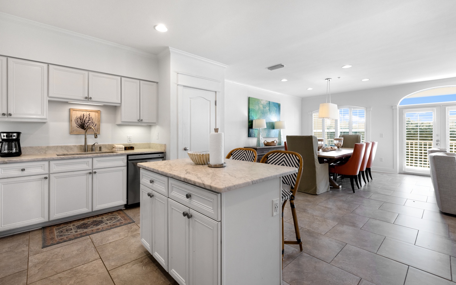 Your spacious kitchen flows seamlessly into the dining area, featuring elegant white cabinetry, modern appliances, and a convenient island for meal prep and casual dining.