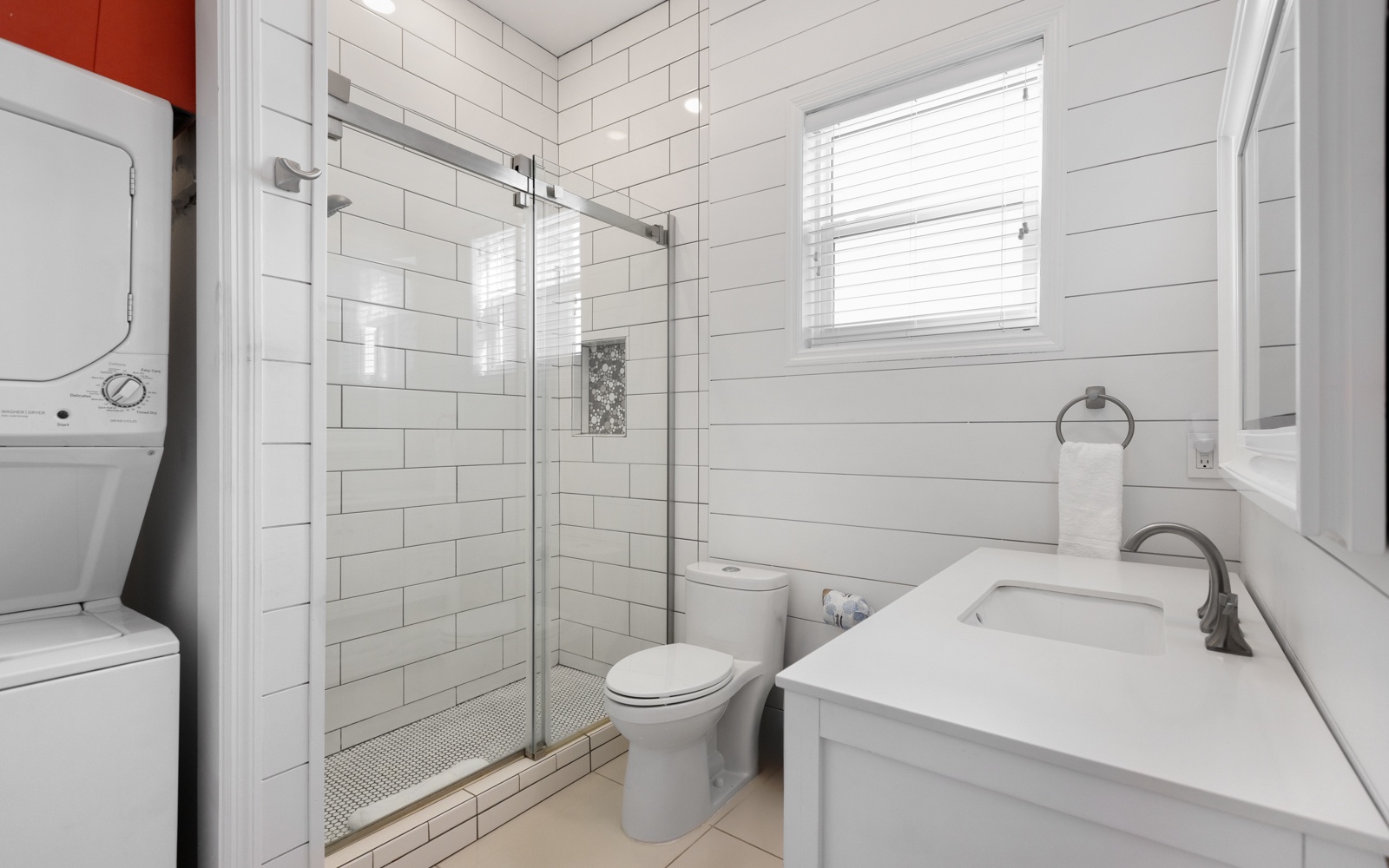 Unwind in your bright, modern bathroom featuring a spacious glass shower, crisp white subway tiles, and fresh towels waiting for you.