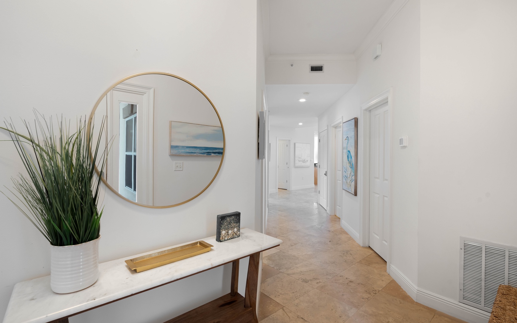 Step into your welcoming hallway where coastal artwork and modern touches create a serene first impression.