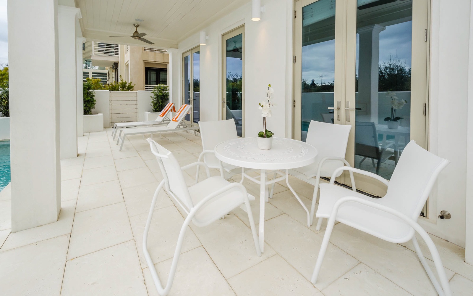 Relax on your private covered terrace with elegant white dining furniture overlooking the sparkling pool area.