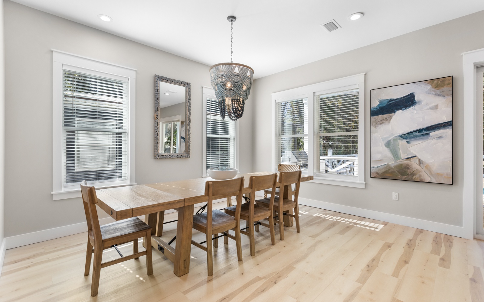 Your elegant dining space features a warm wood table for six under a stunning chandelier, perfect for memorable meals together.