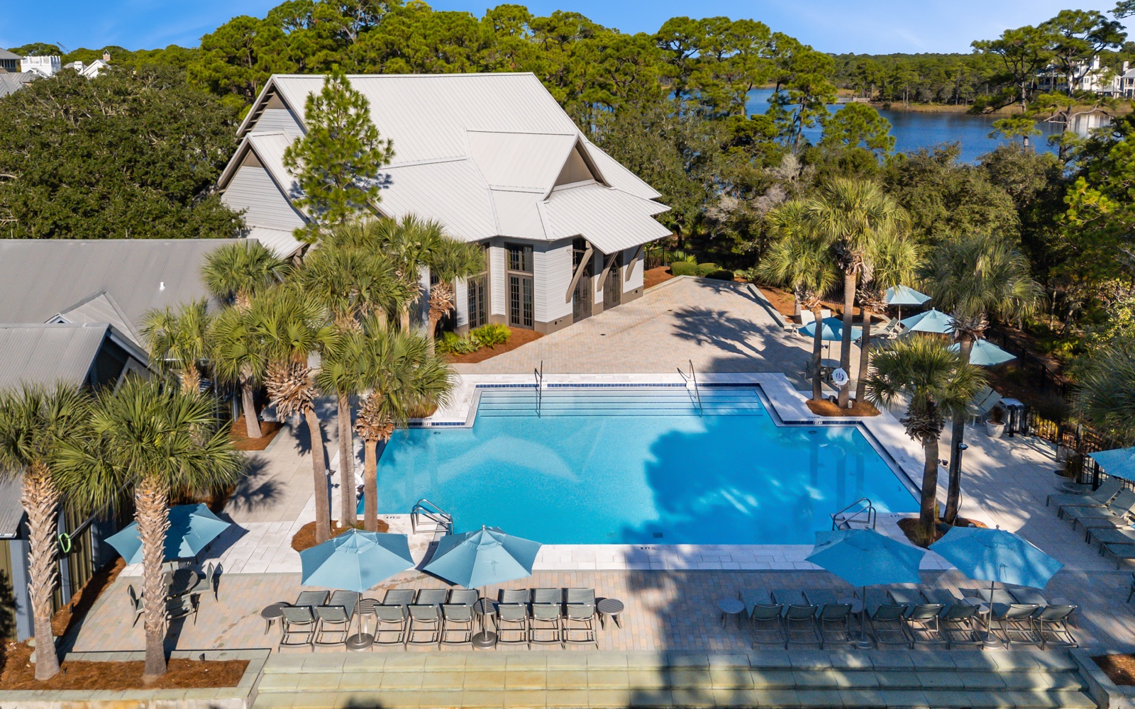 Stunning aerial view of the resort's pristine pool complex surrounded by tropical palms and natural coastal landscape.