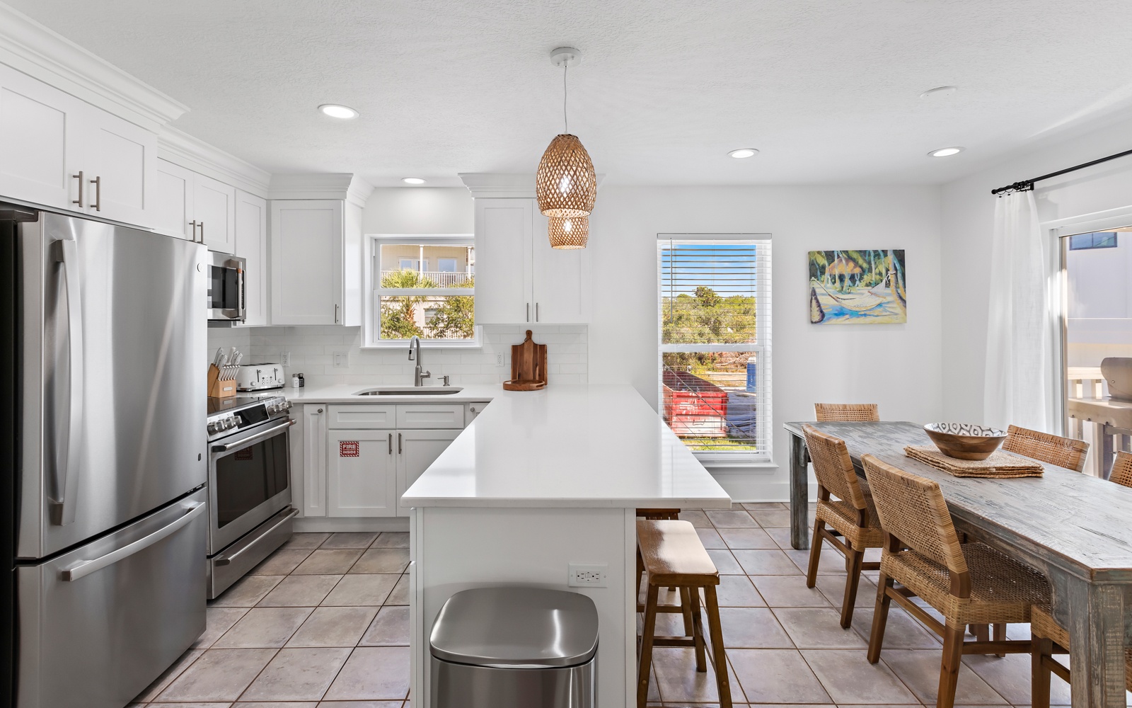 Your bright, modern kitchen features white cabinets, stainless steel appliances, and a spacious island perfect for meal prep and casual dining together.
