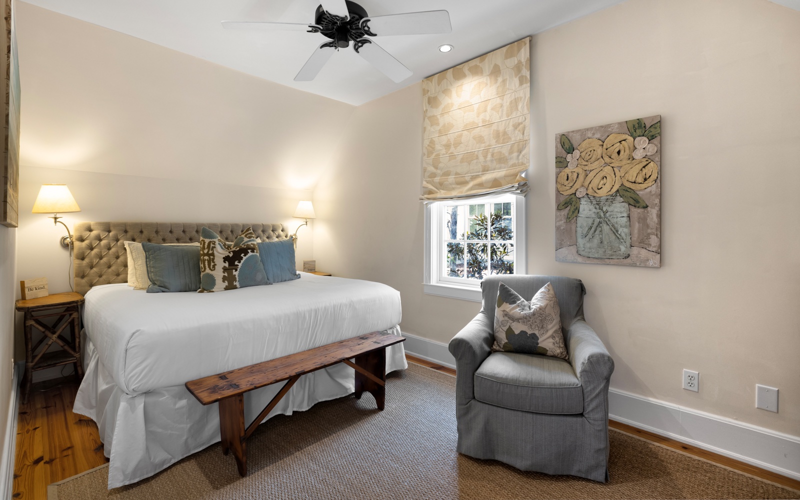 Your serene bedroom features a plush tufted headboard, cozy reading chair, and gentle natural light streaming through elegant window treatments.