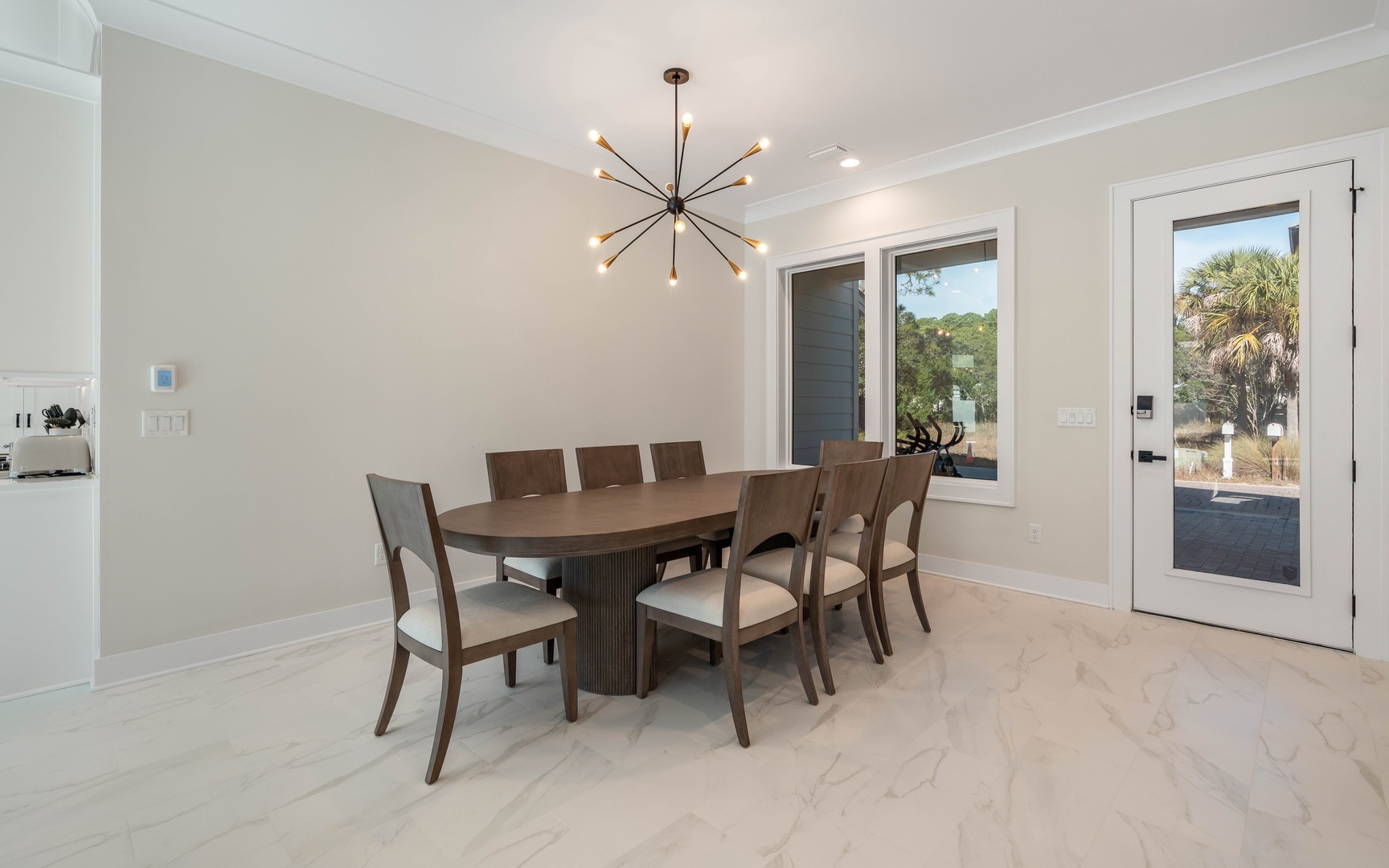 Gather your group around this elegant dining table for eight, where memorable meals unfold beneath modern starburst lighting.