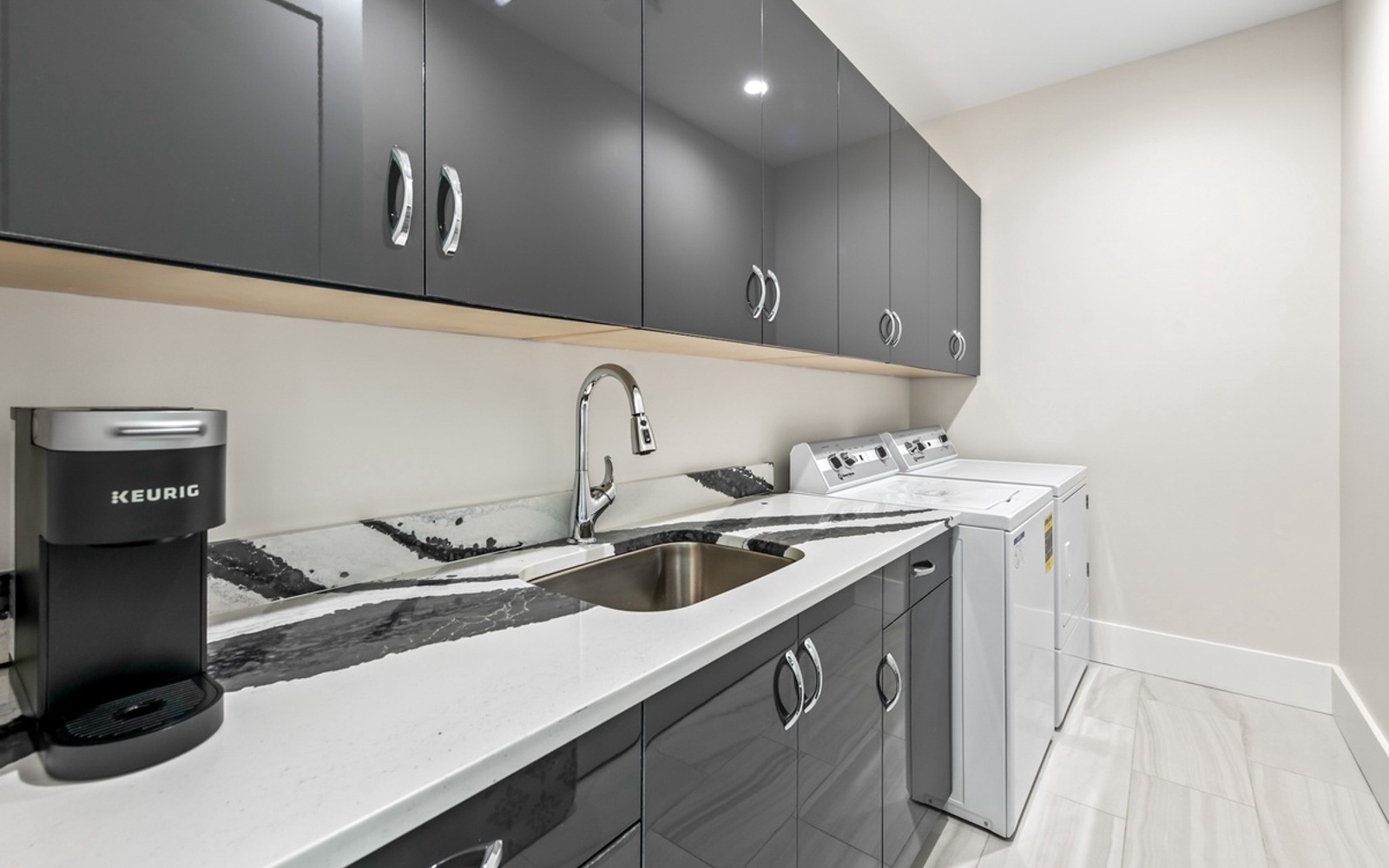 Your laundry space features marble countertops, modern cabinetry, and a convenient coffee station for busy mornings.