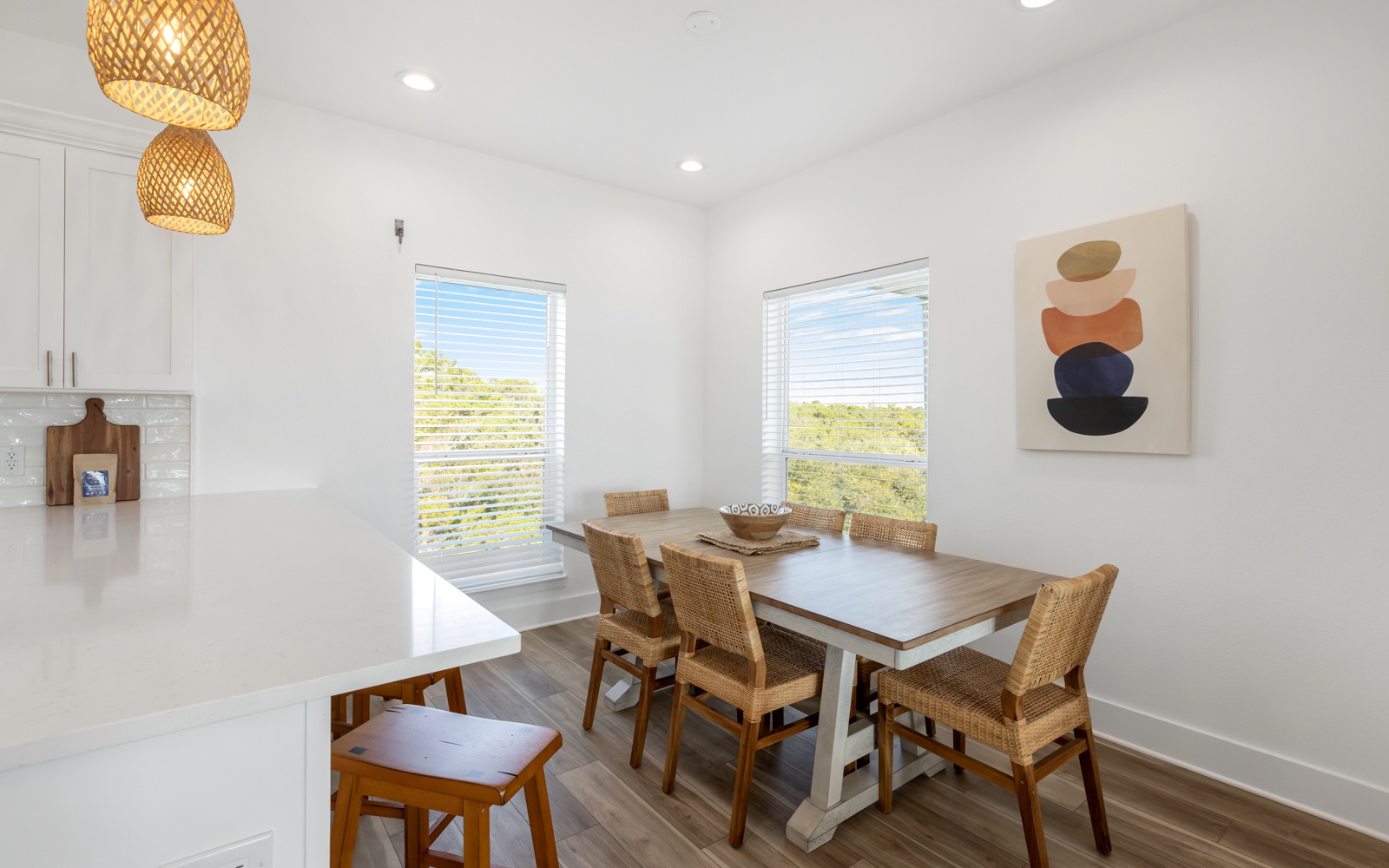 Gather around your stylish dining table where woven pendant lights cast a warm glow for memorable meals together.