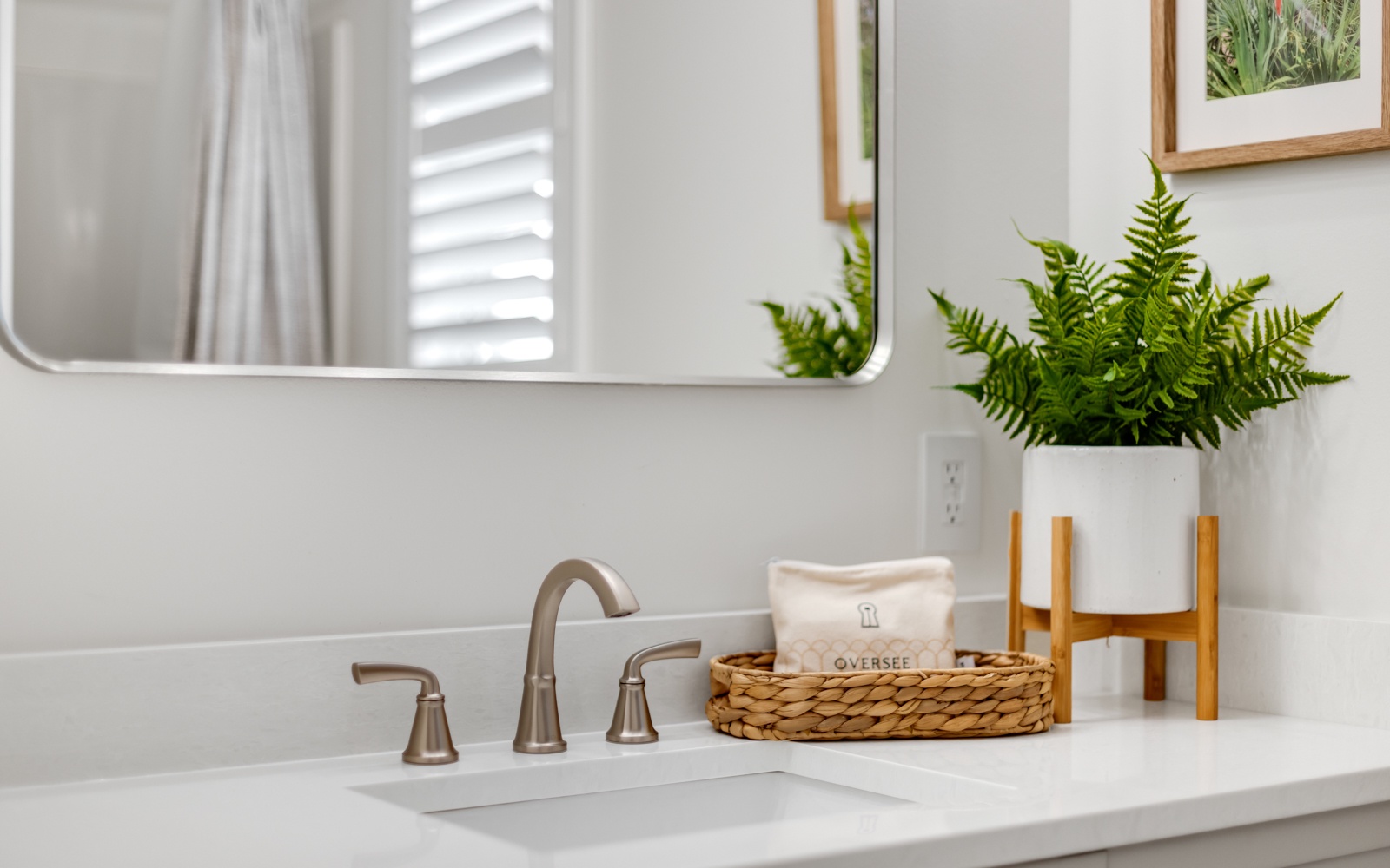 Freshen up in your stylishly appointed bathroom featuring a gleaming vanity, elegant fixtures, and thoughtful touches like fresh greenery.