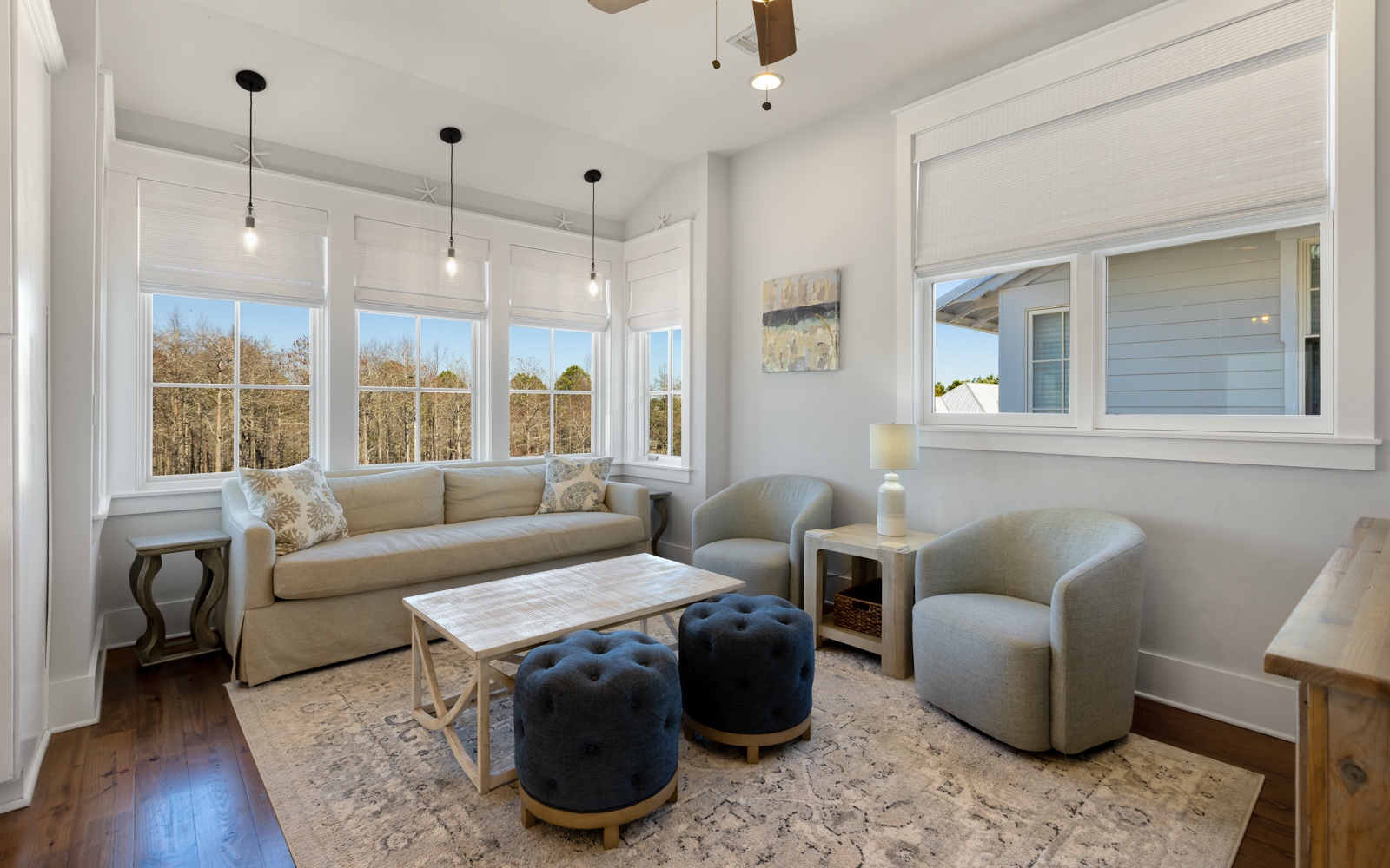 Unwind in your bright living space with plush seating and peaceful treetop views through oversized windows.