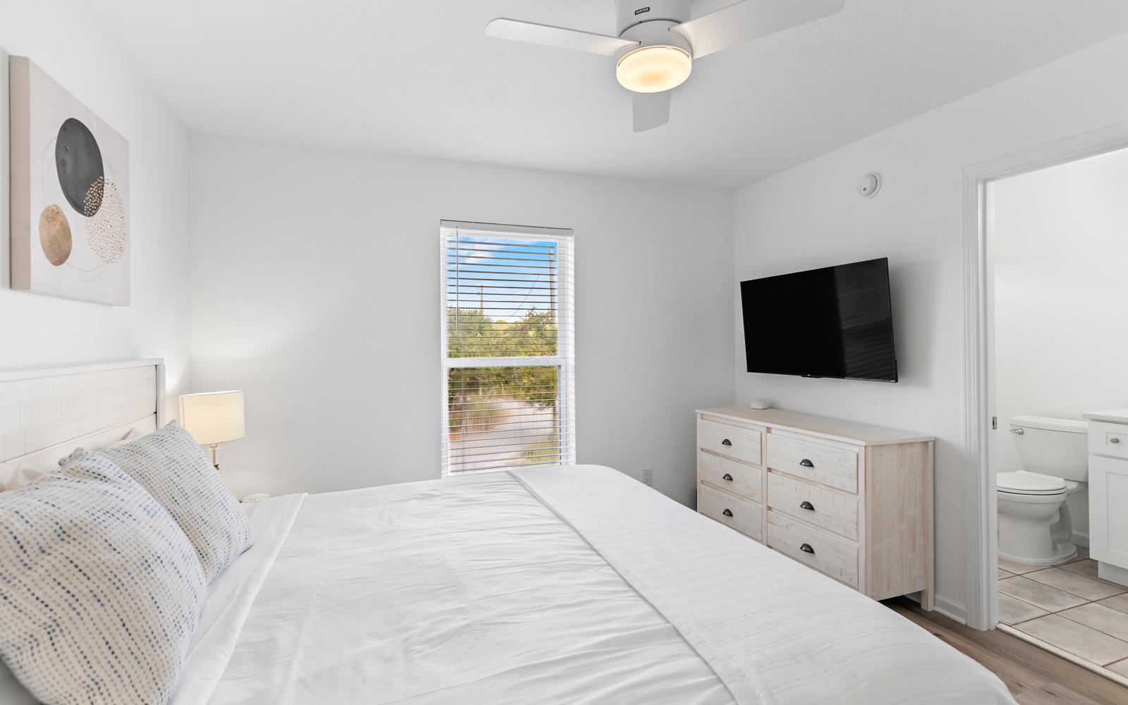 Relax in your bright bedroom featuring a comfortable bed, modern TV, and convenient ensuite bathroom for ultimate comfort.