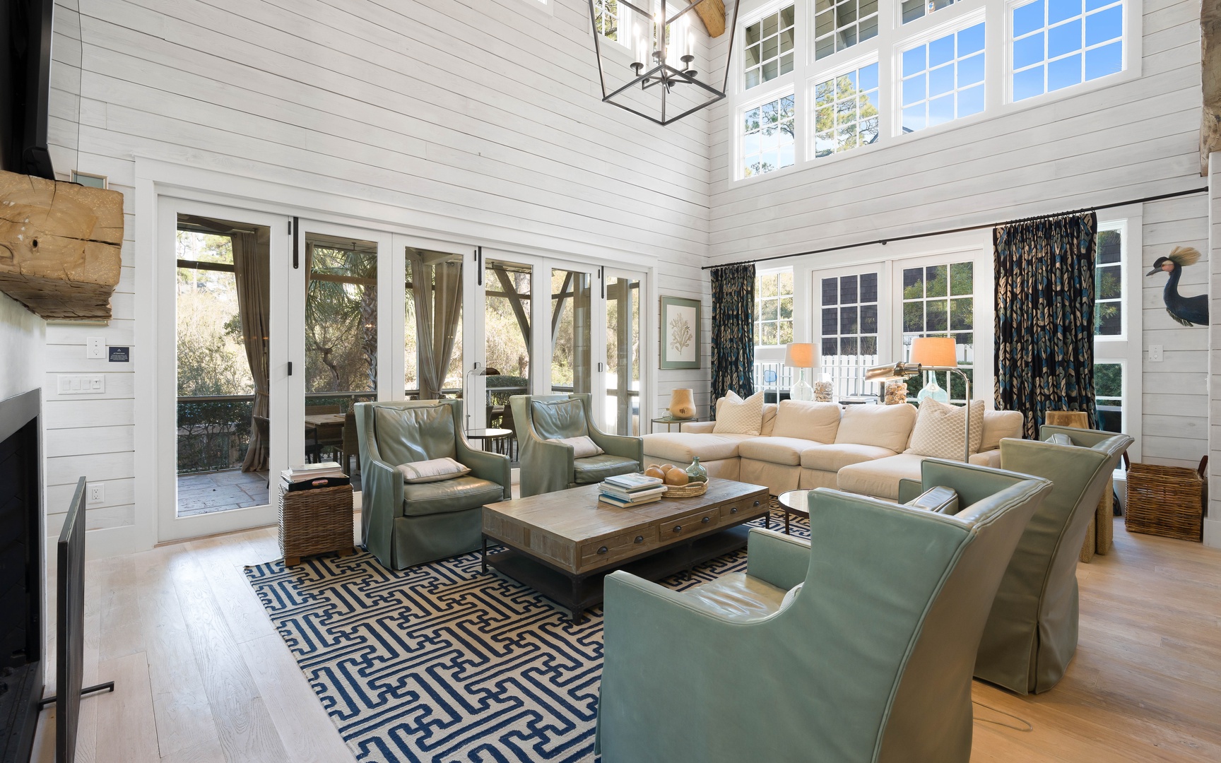 Relax in this stunning living room with soaring ceilings, plush seating, and abundant natural light streaming through French doors.