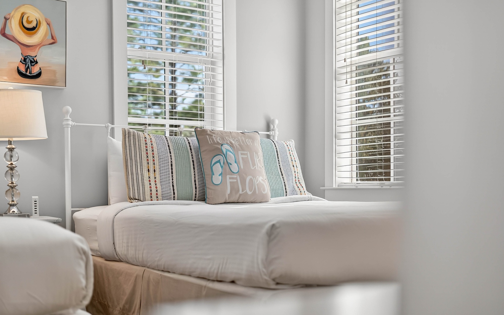 Sink into this bright, airy bedroom where soft linens and coastal-inspired pillows create your perfect retreat.