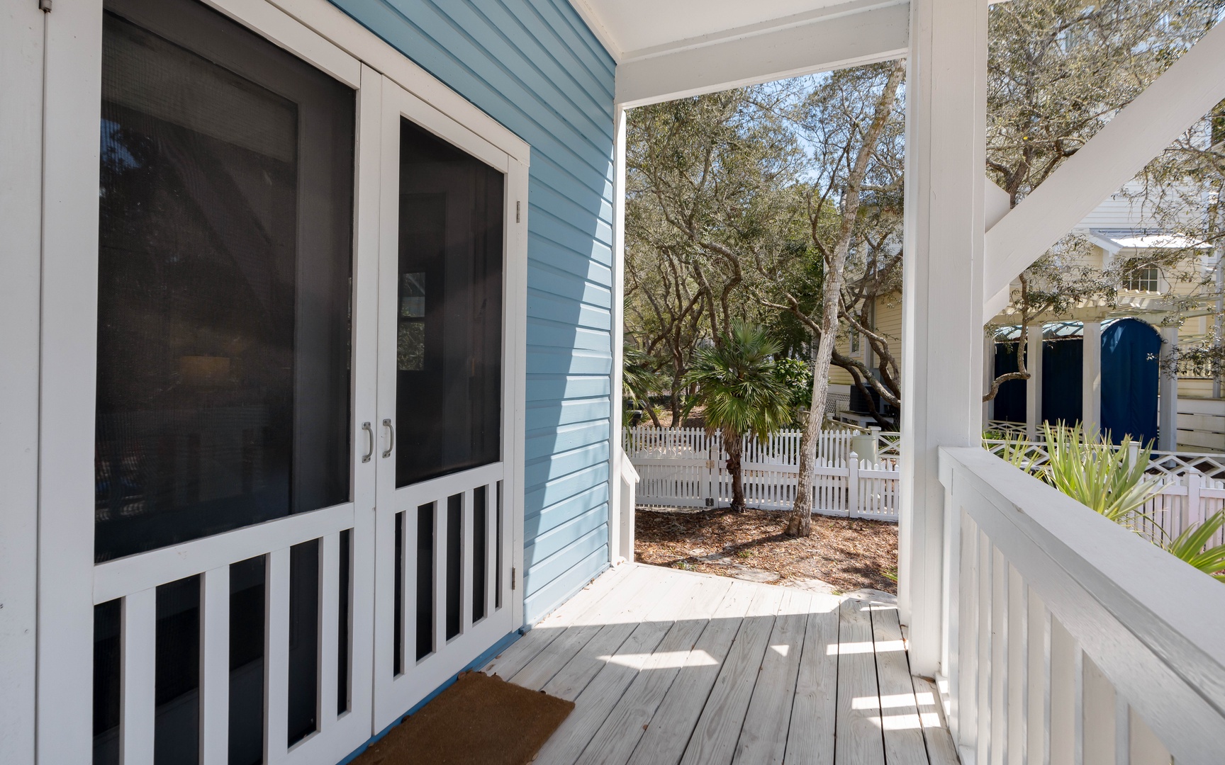 Your private entrance opens to a charming covered porch with peaceful garden views through mature trees.