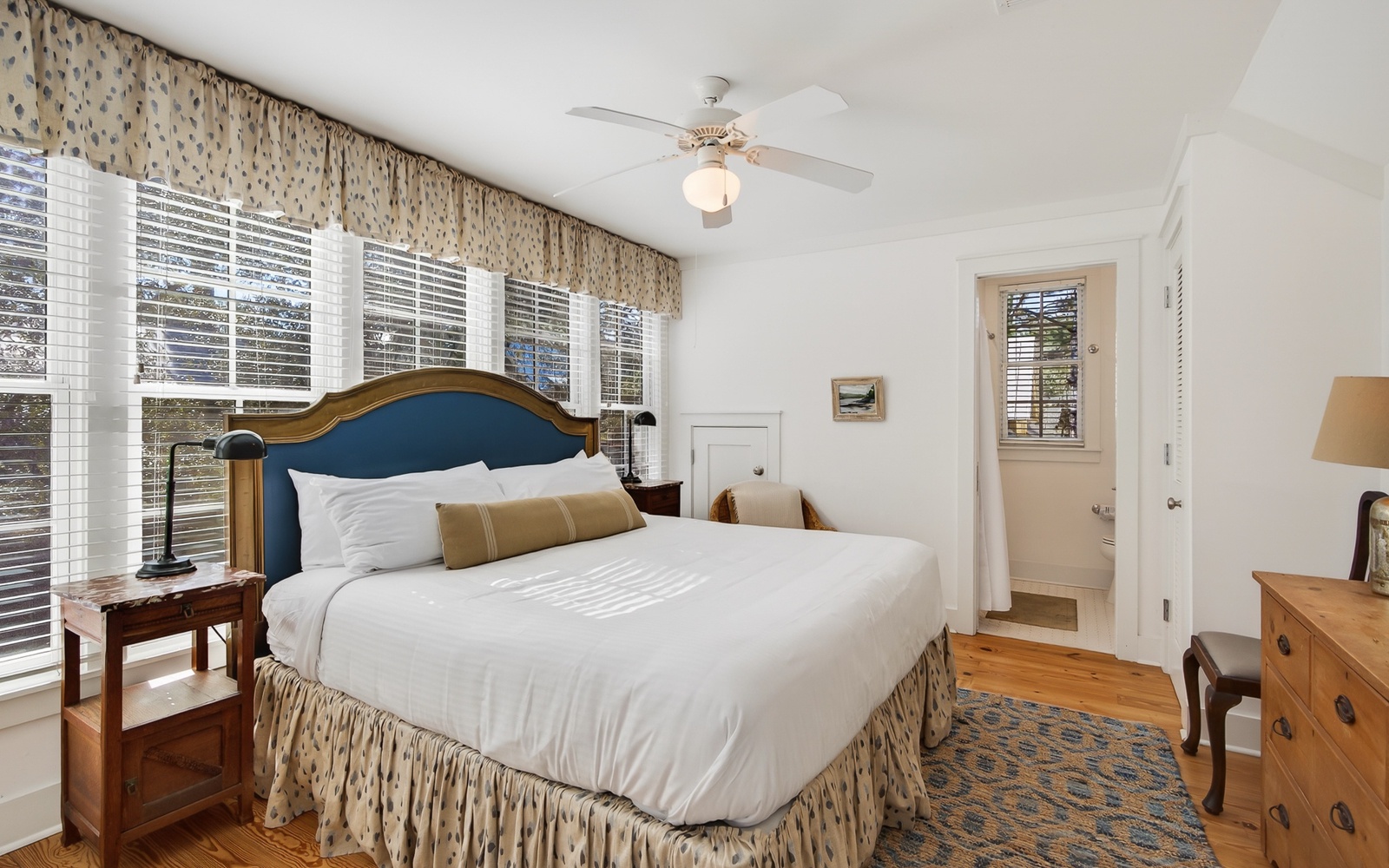 Drift into restful sleep in your cozy bedroom featuring crisp white linens, elegant decor, and gentle ceiling fan keeping you comfortable.