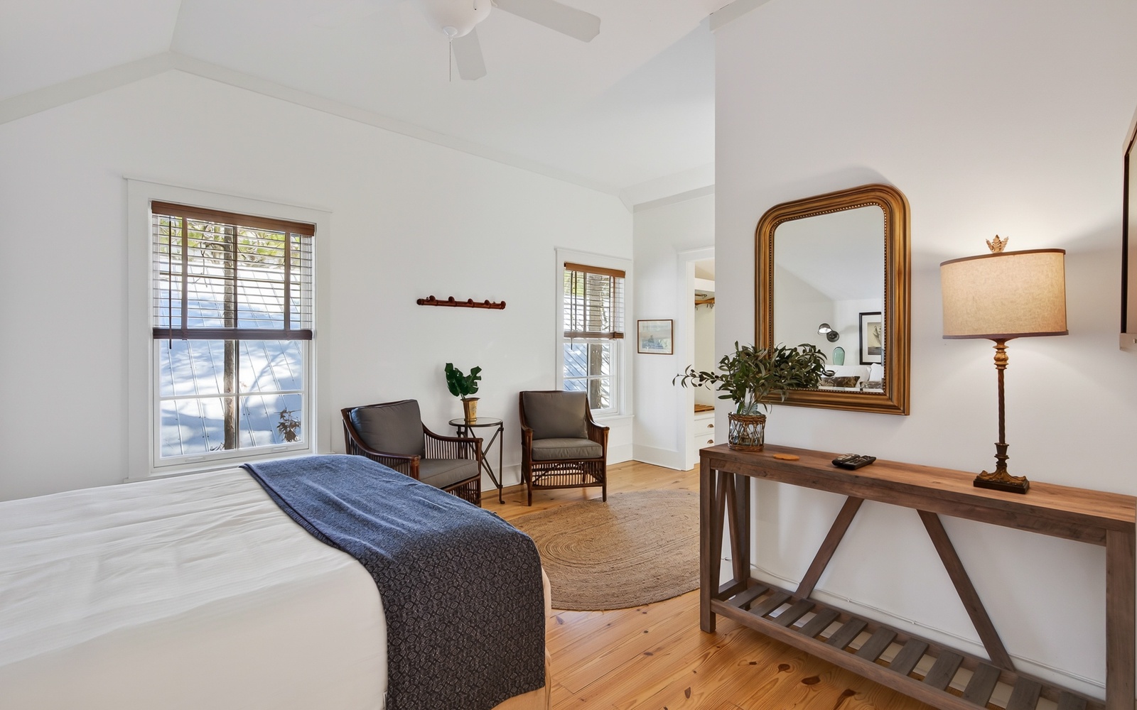 Wake up in this bright, serene bedroom where natural light streams through plantation shutters and hardwood floors warm your bare feet.