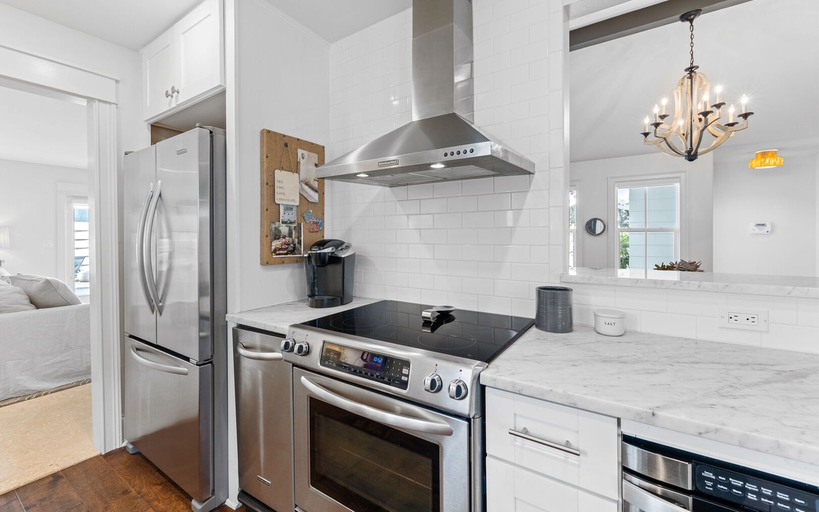 Cook your favorite meals in this bright, modern kitchen featuring stainless steel appliances and elegant marble countertops.