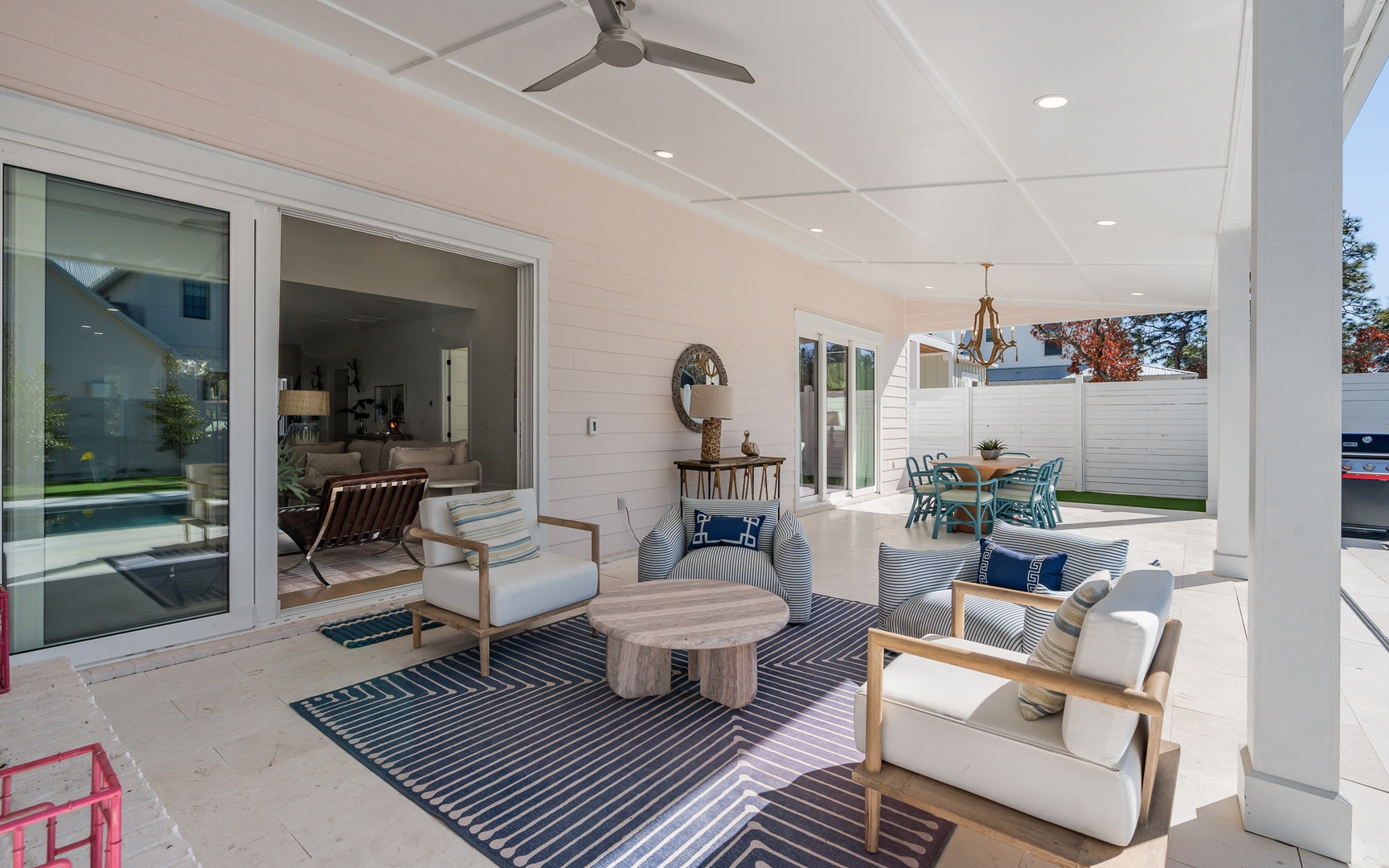 Relax in your covered outdoor living room with plush seating and ceiling fan for perfect comfort.