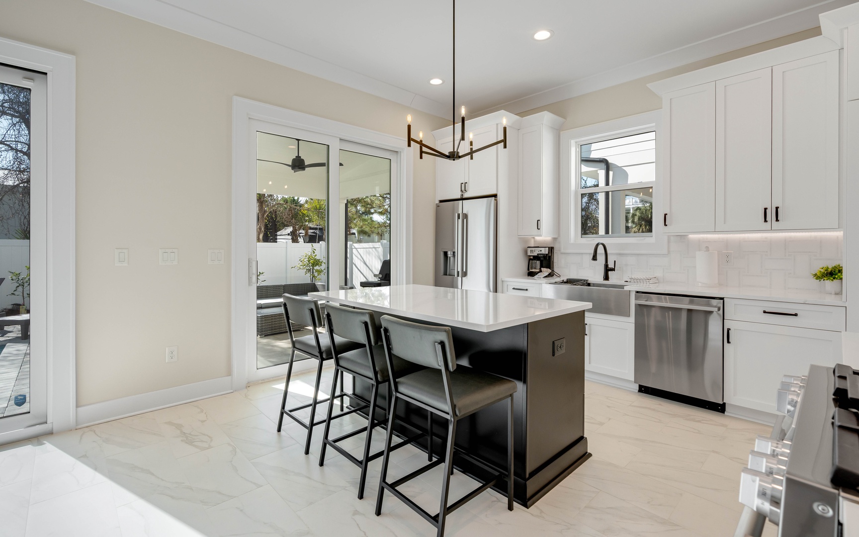 Your gourmet kitchen awaits with sleek white cabinetry, premium stainless appliances, and a spacious island perfect for morning coffee or evening gatherings.