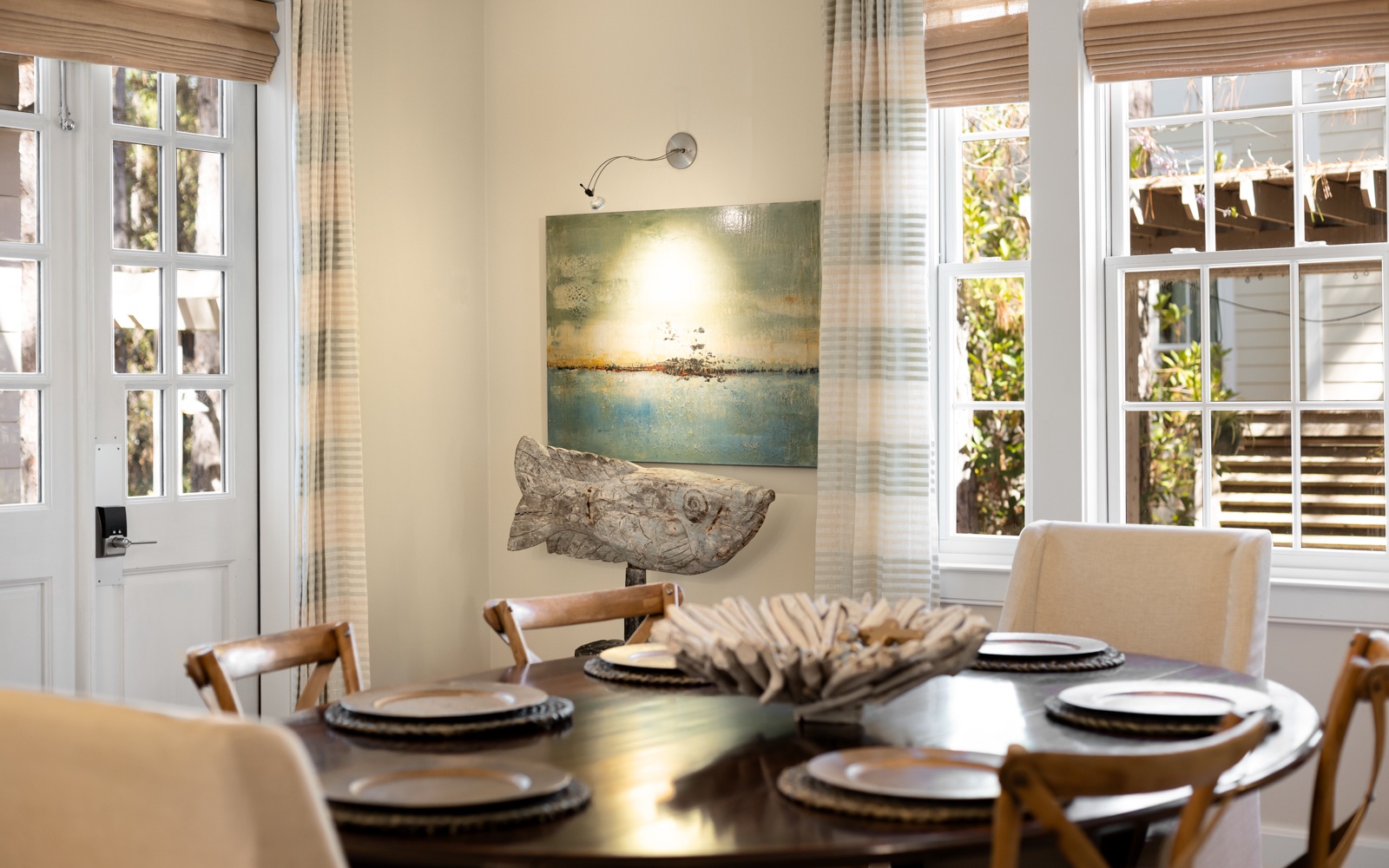 Gather around this elegant dining table where natural light streams through French doors, creating the perfect setting for memorable meals together.